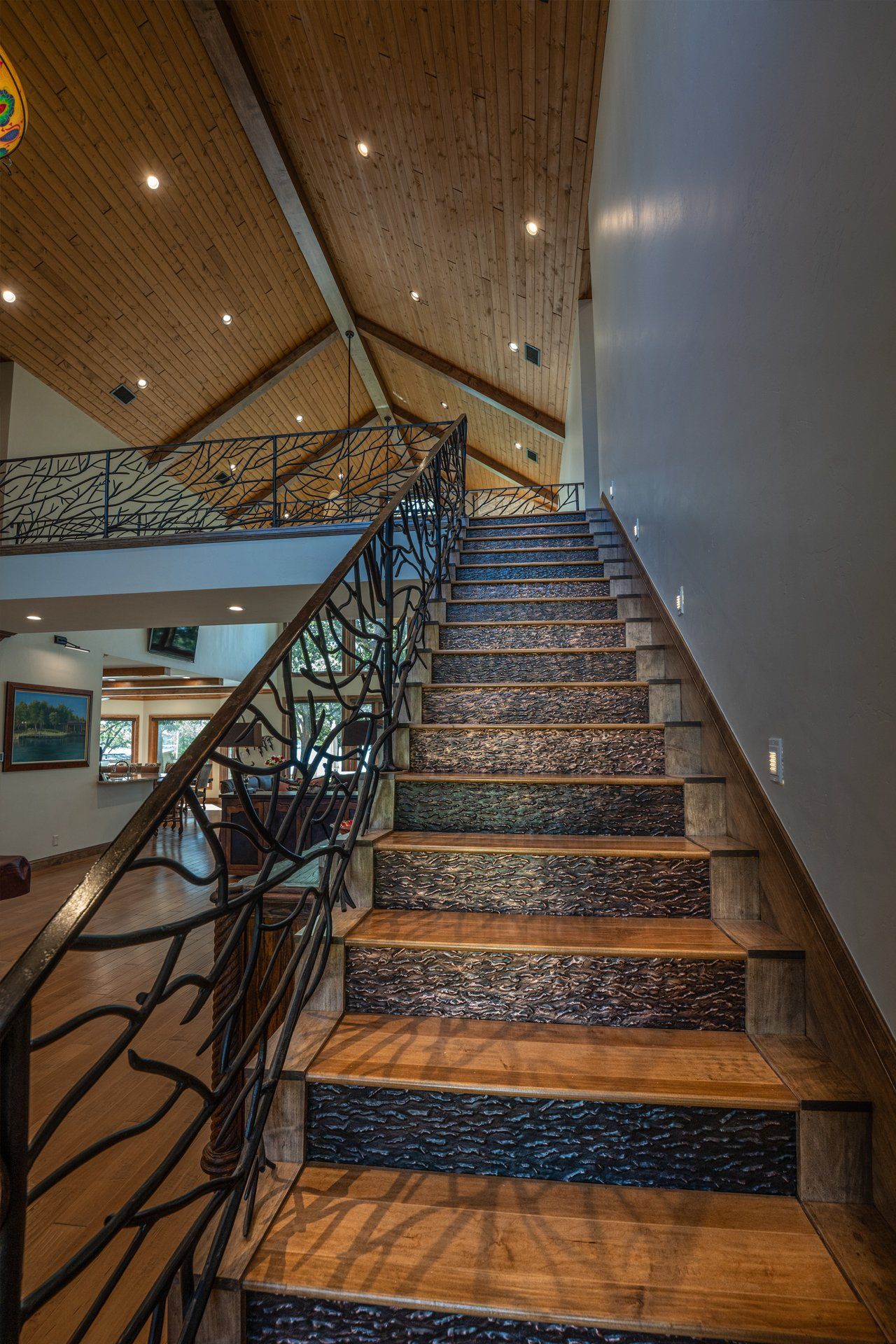 A wooden staircase with a wrought iron railing in a house.