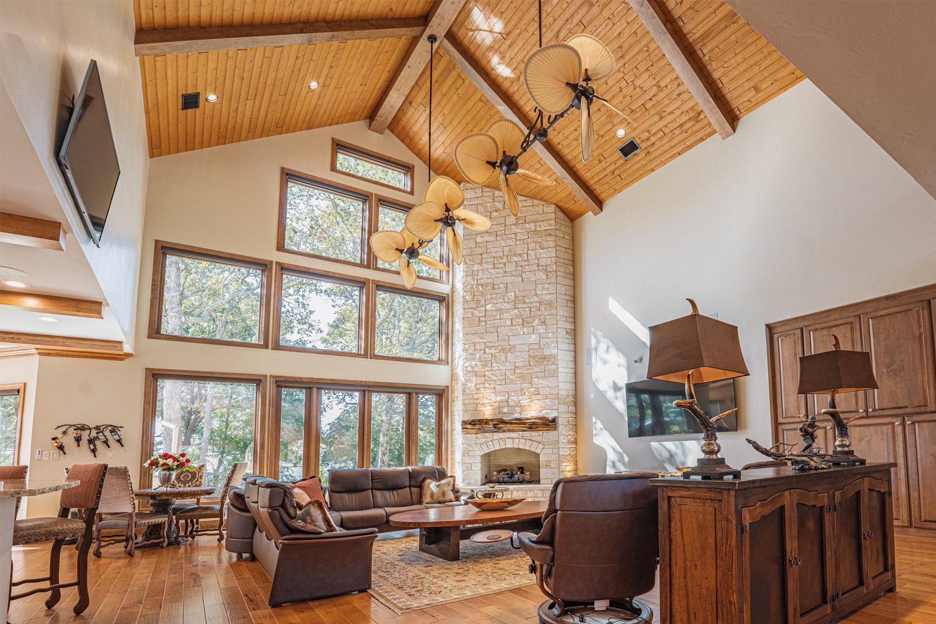 A living room with a vaulted ceiling and lots of windows.