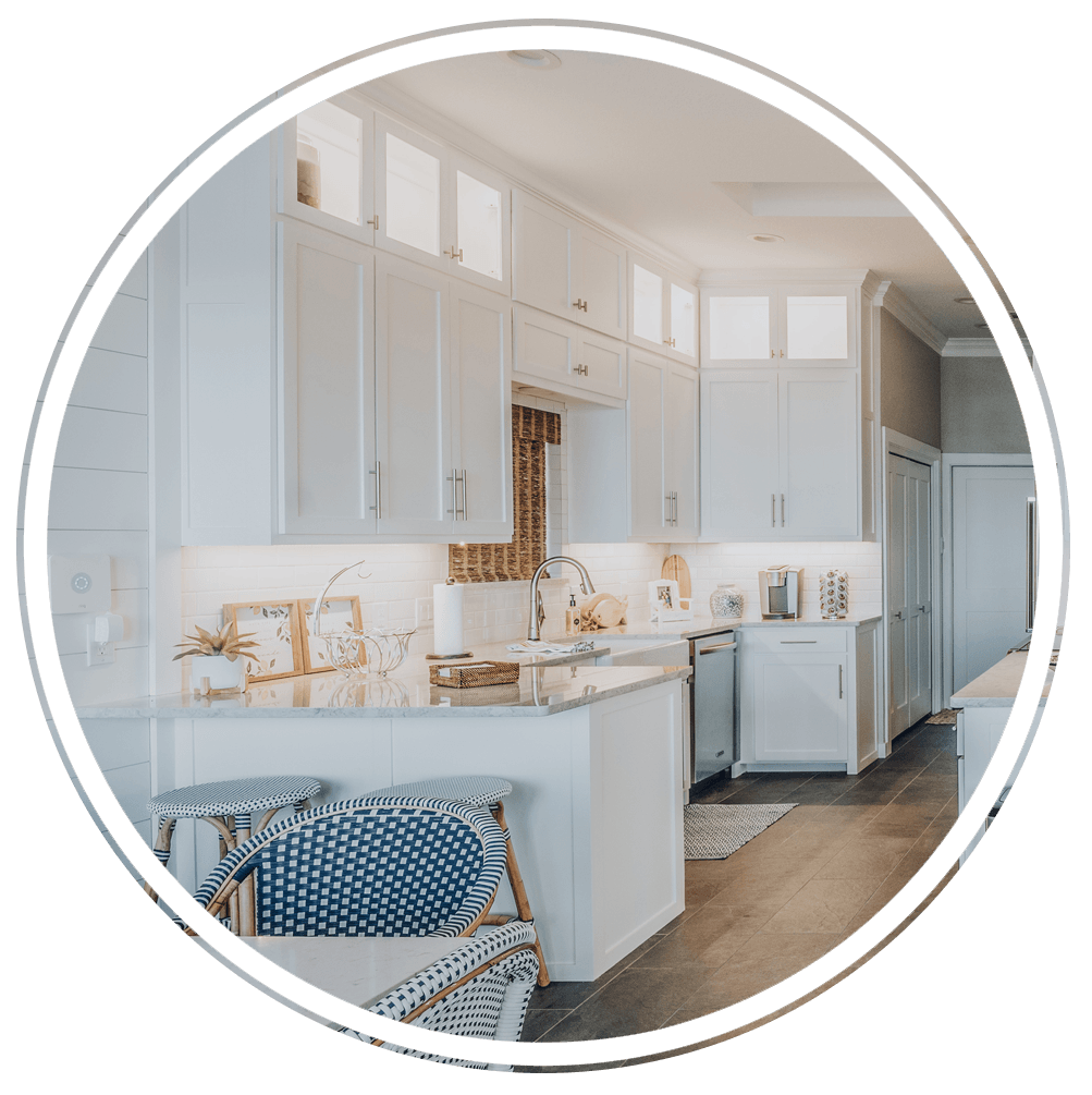 A kitchen with white cabinets , a sink , and a chair in a circle.