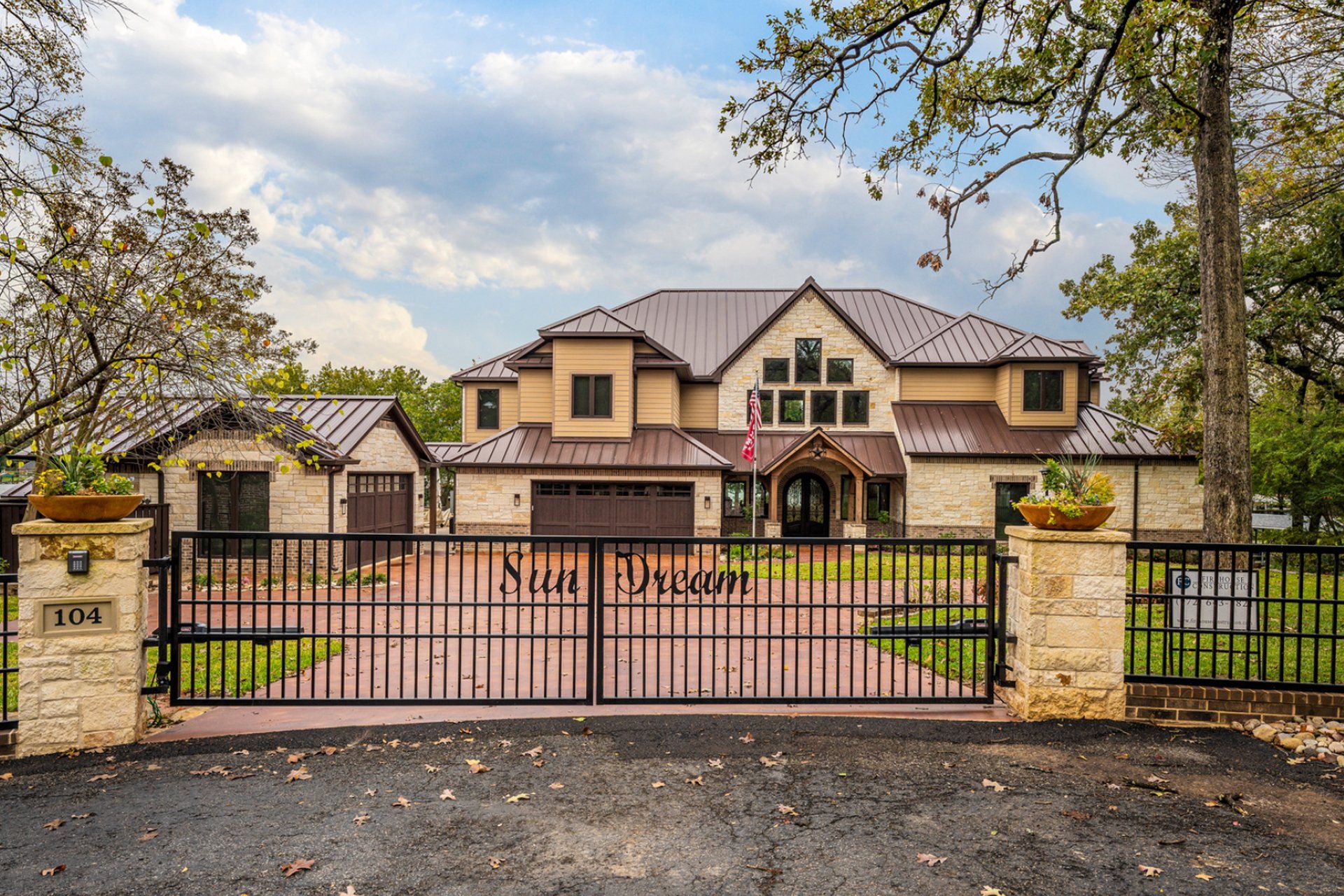 A large house with a gated driveway leading to it
