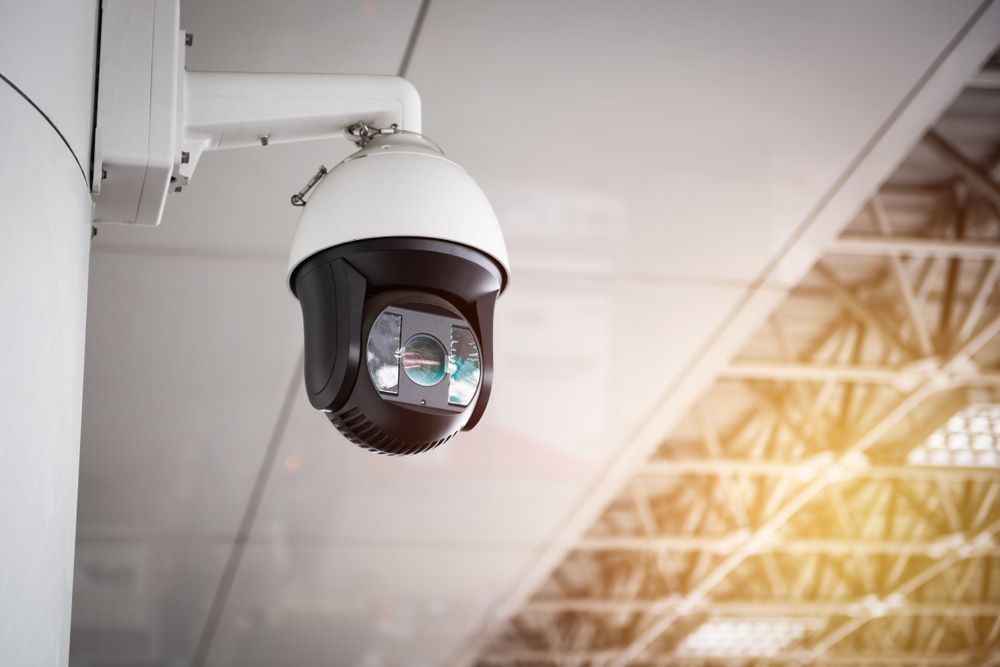 A Security Camera Is Hanging From The Ceiling Of A Building — SPL Security Solutions in Bundall, QLD