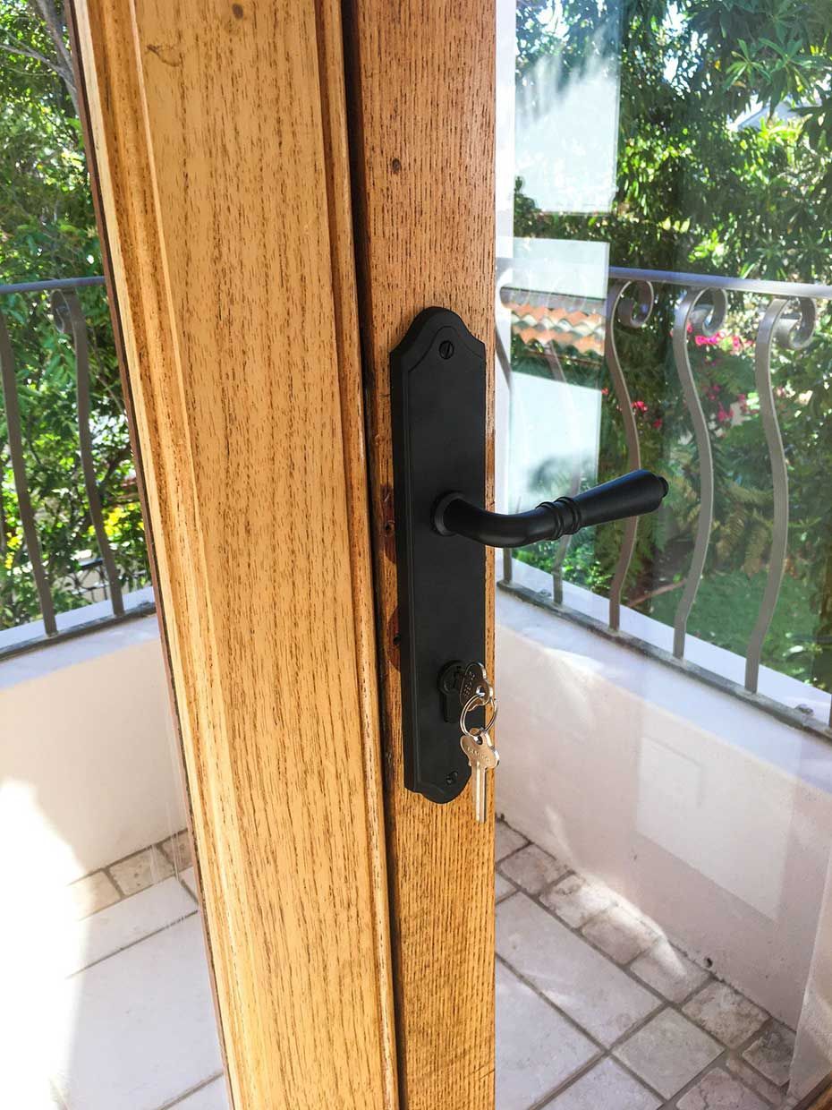 A Close Up of a Door With a Black Handle and a Key — SPL Security Solutions in Bundall, QLD