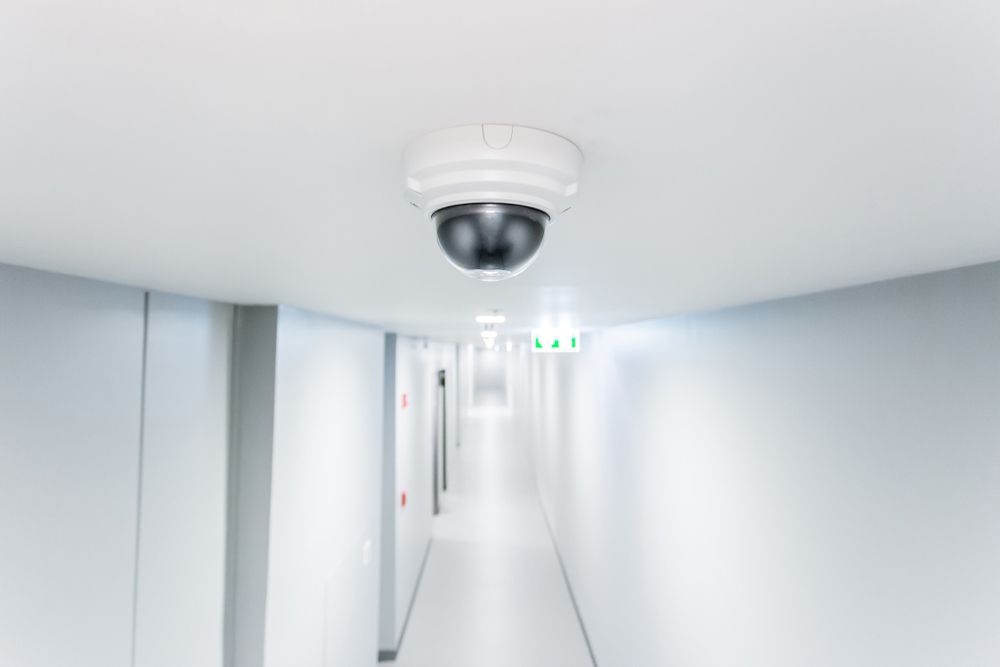 A Security Camera Is Hanging From The Ceiling Of A Hallway — SPL Security Solutions In Surfers Paradise, QLD