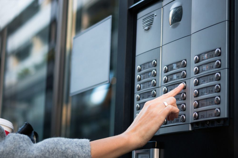 Person Is Pressing A Button On A Doorbell — SPL Security Solutions in Bundall, QLD
