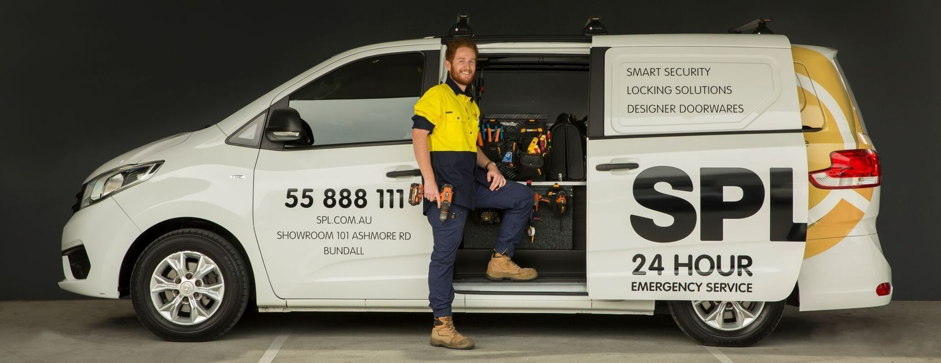 A Man Is Standing Next to A White Van with The Door Open - SPL Security Solutions In Bundall, QLD