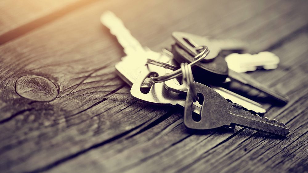 A Bunch Of Keys Are Sitting On A Wooden Table — SPL Security Solutions In Ashmore, QLD