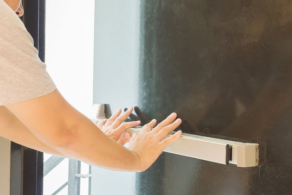 A Person is Pressing a Panic Bar on a Door — SPL Security Solutions In Bundall, QLD