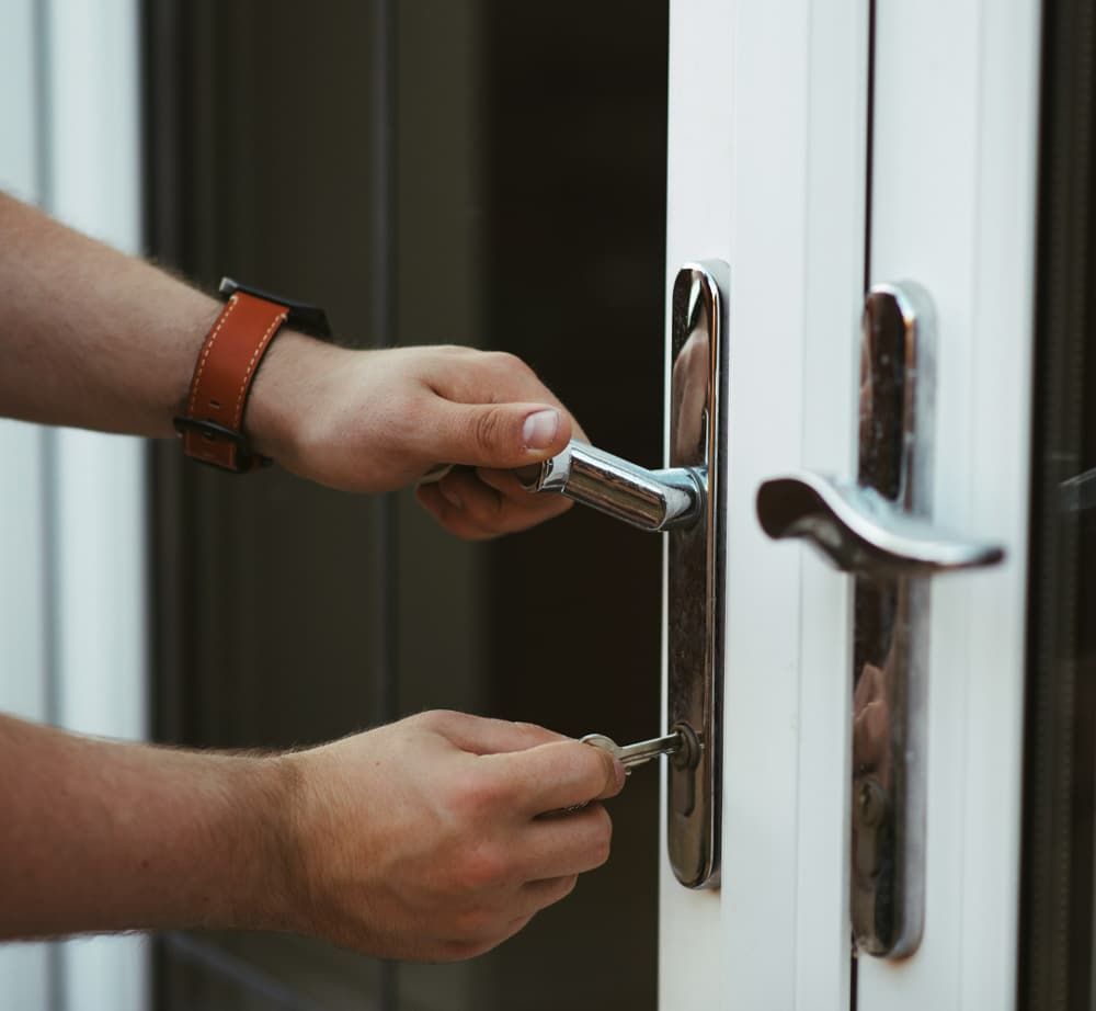 A Person is Opening a Door With a Key — SPL Security Solutions in Bundall, QLD