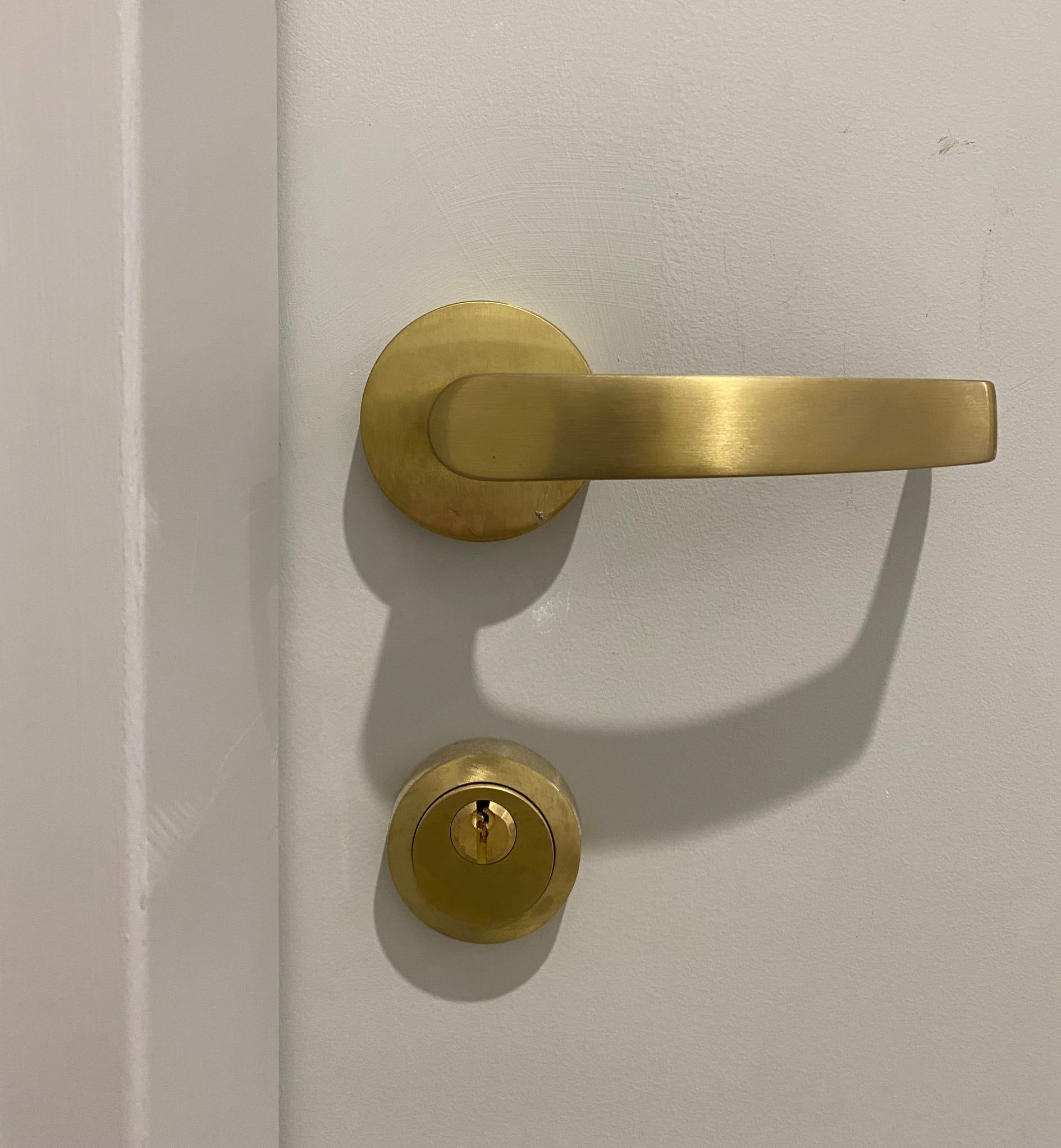 close up of gold door hardware on white door