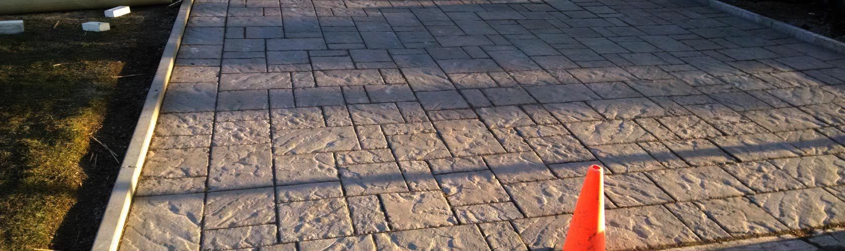 brown unistone driveway with orange cone on it