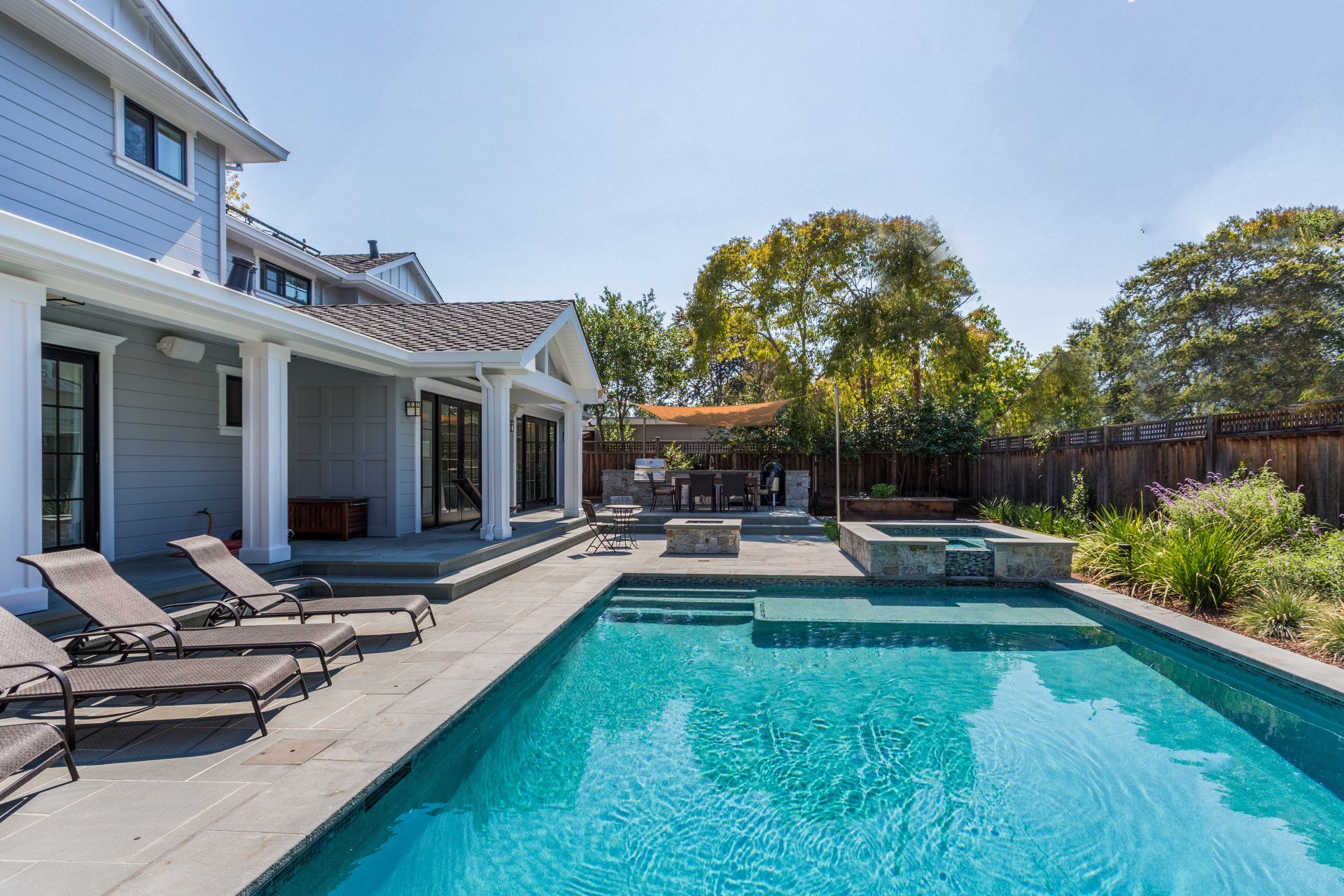 outdoor rectangular pool with patio chairs poolside