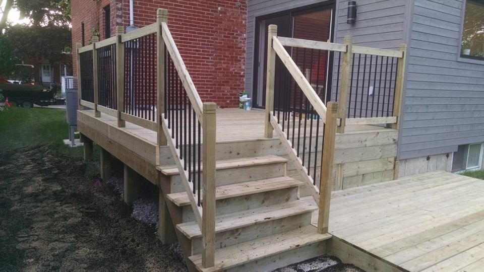 beige wooden deck with staricase and railing