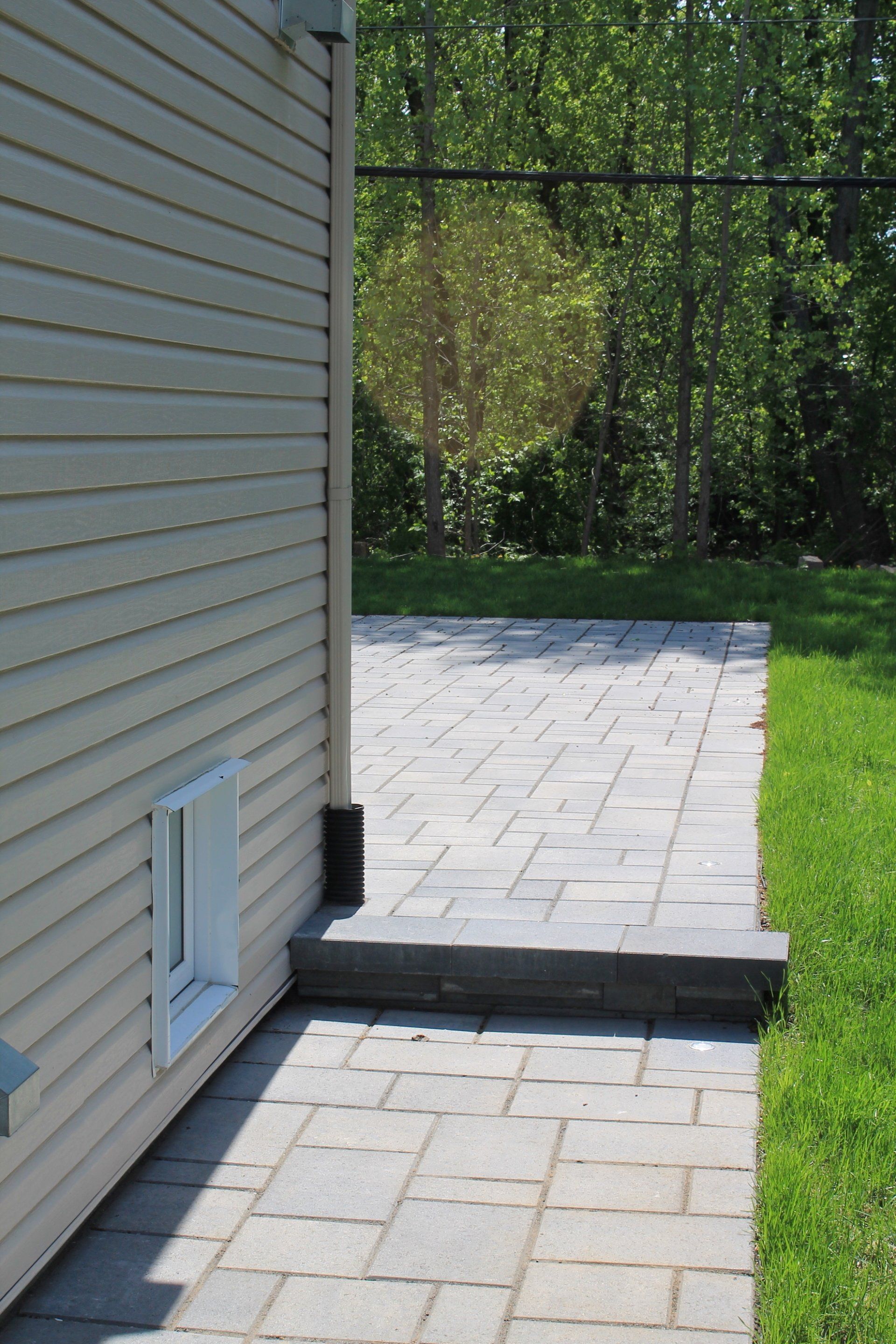 beige unistone walkway leading into backyard