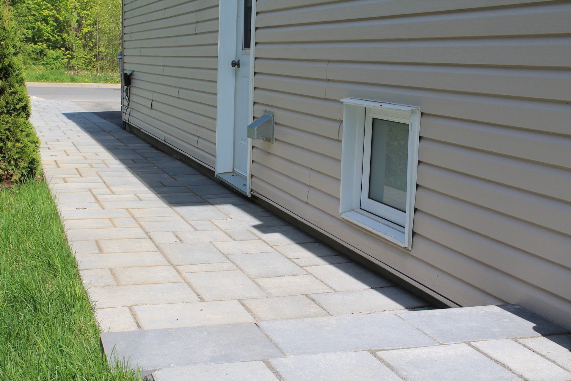 beige unistone walkway next to beige house