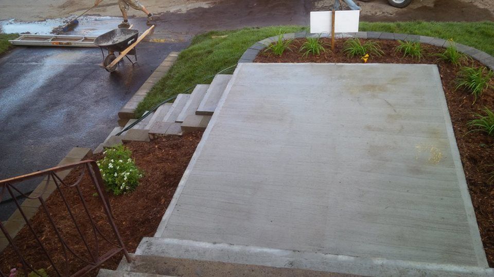 concrete staircase next to flower beds