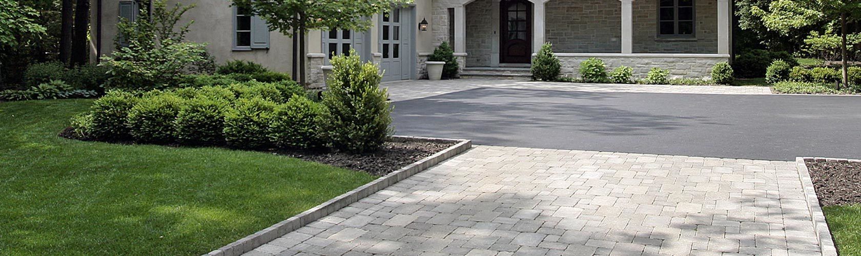 unistone parking lot with green grass next ot it