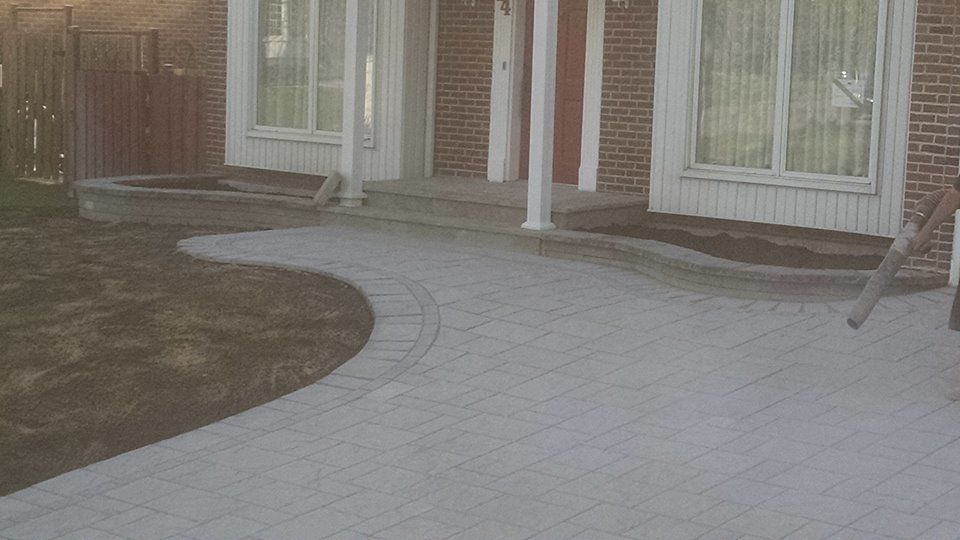 home entrance with unistone driveway and white support columns