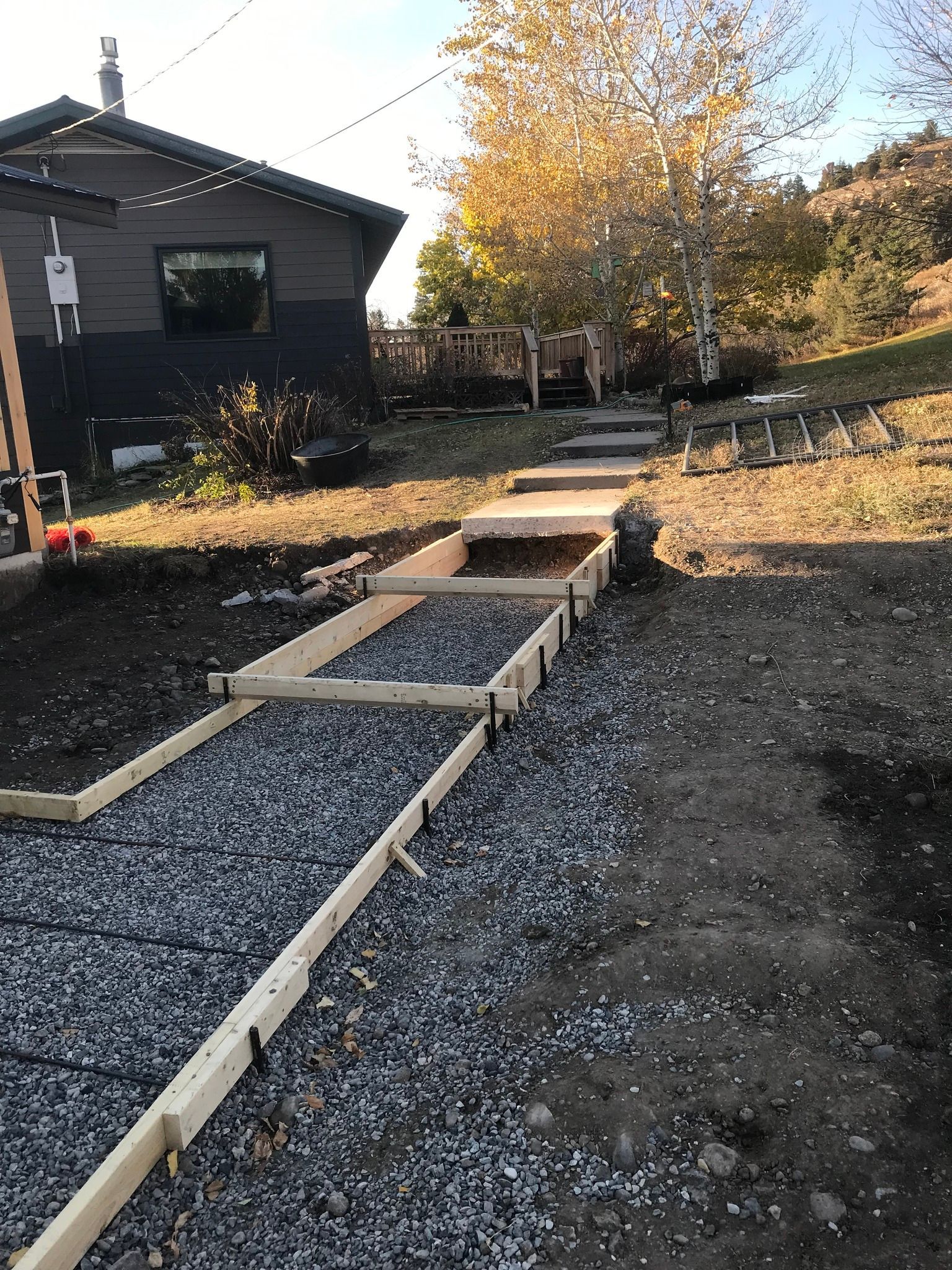 A concrete walkway is being built in front of a house.