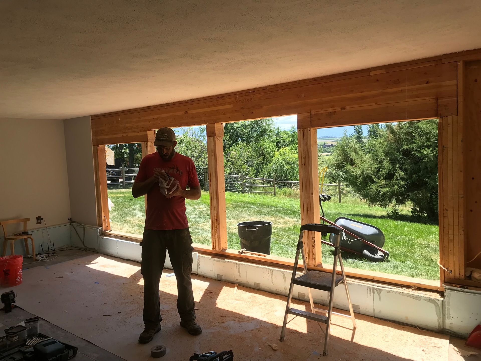 A man is standing in front of a large window in a room.