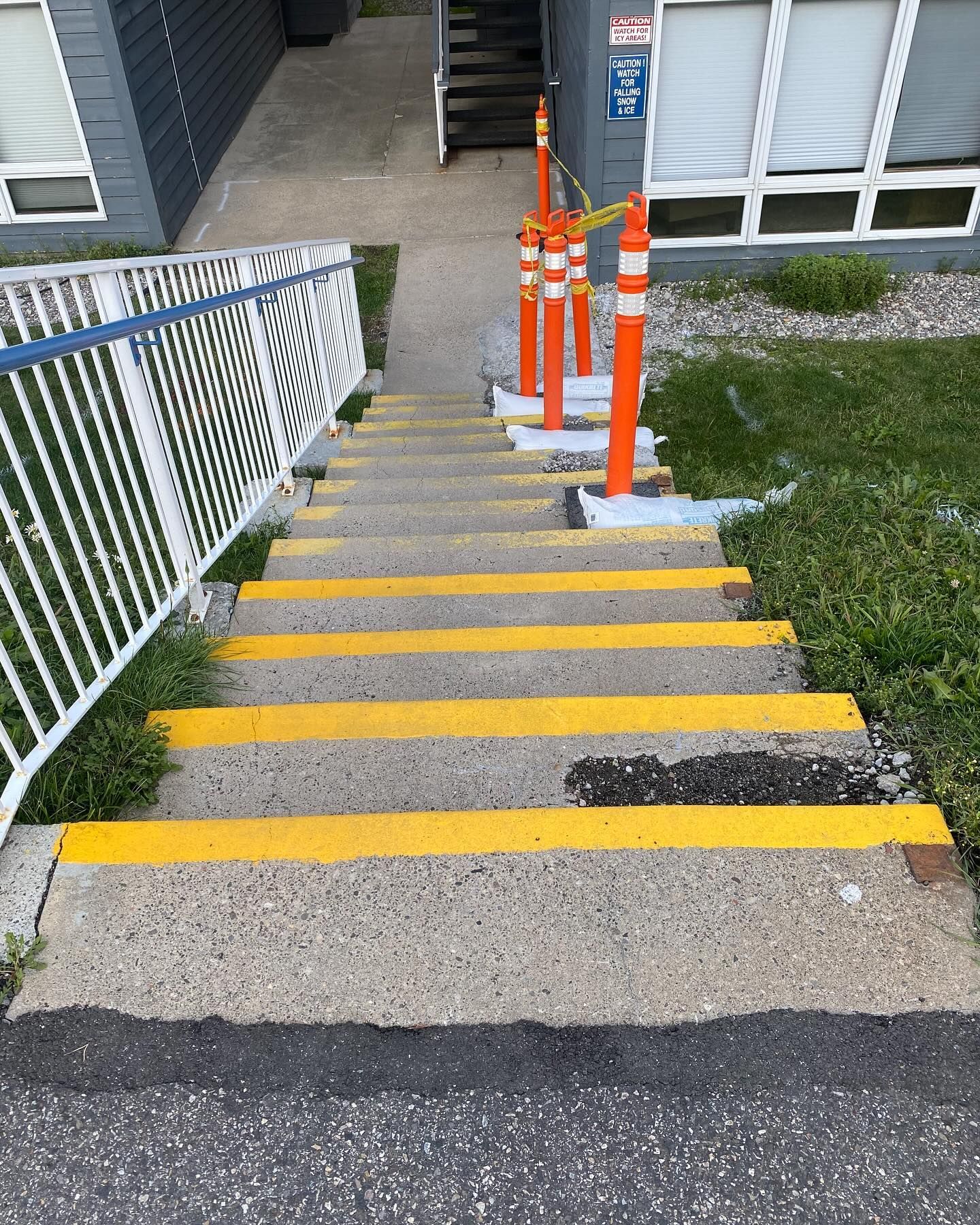 A set of stairs leading up to a building with yellow stripes on the steps.