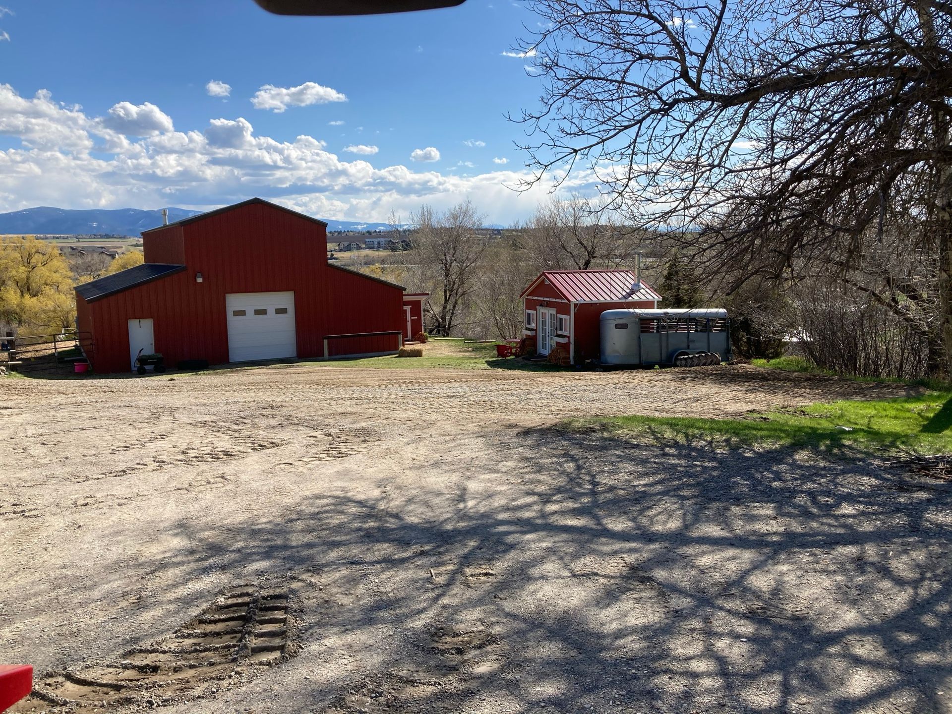 A red barn is sitting in the middle of a dirt field.