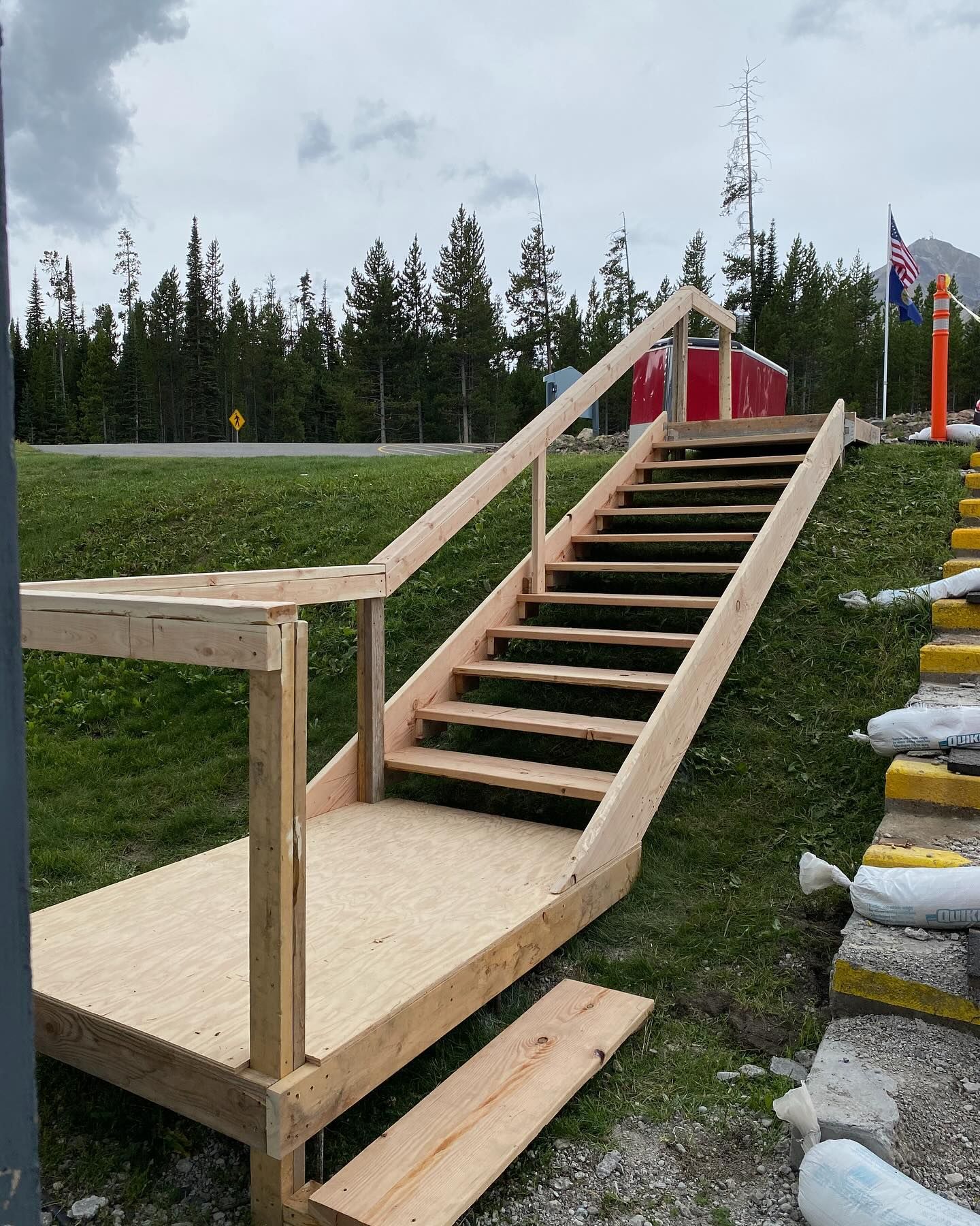 A set of wooden stairs going up a grassy hill