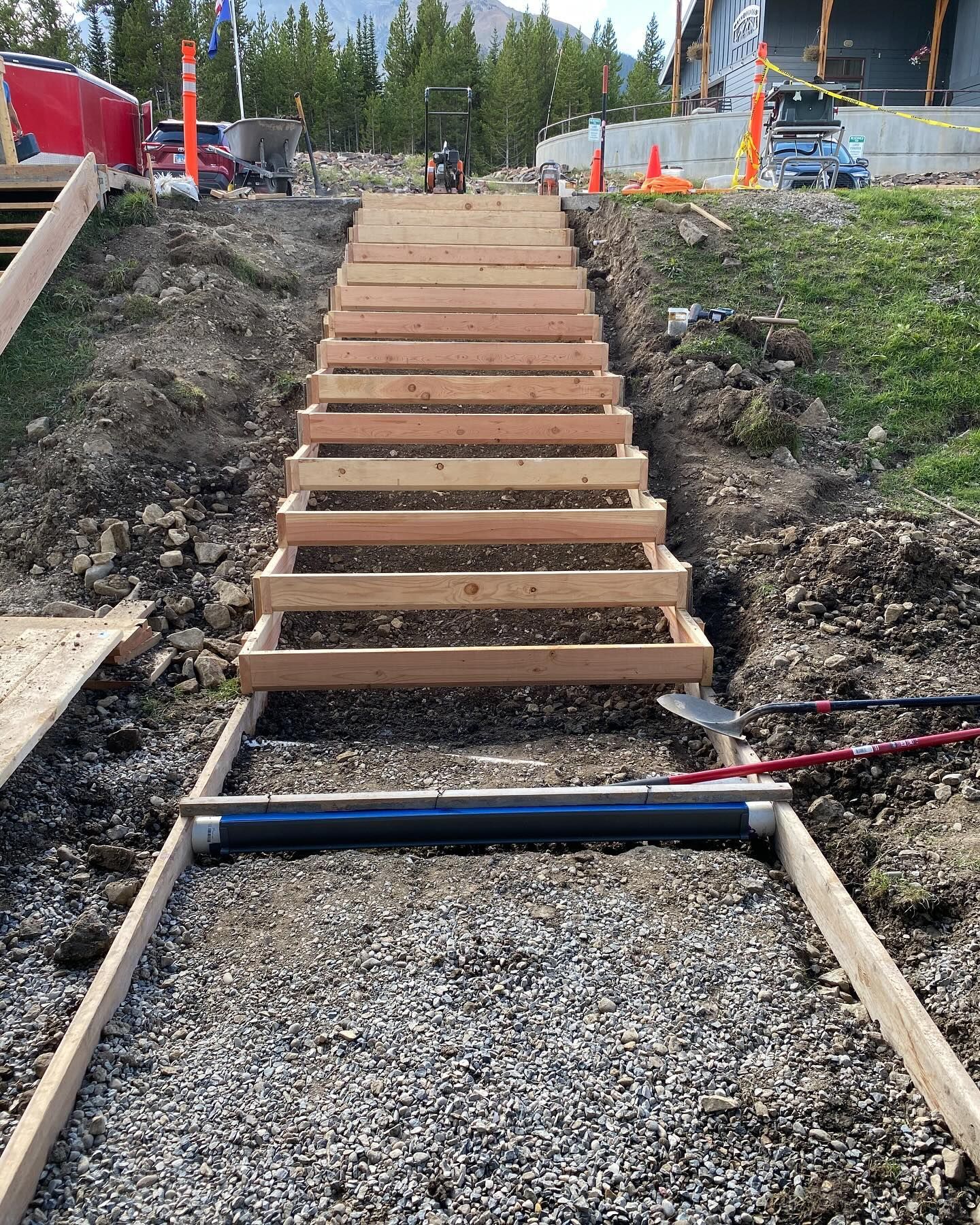 A wooden staircase is being built in the dirt.