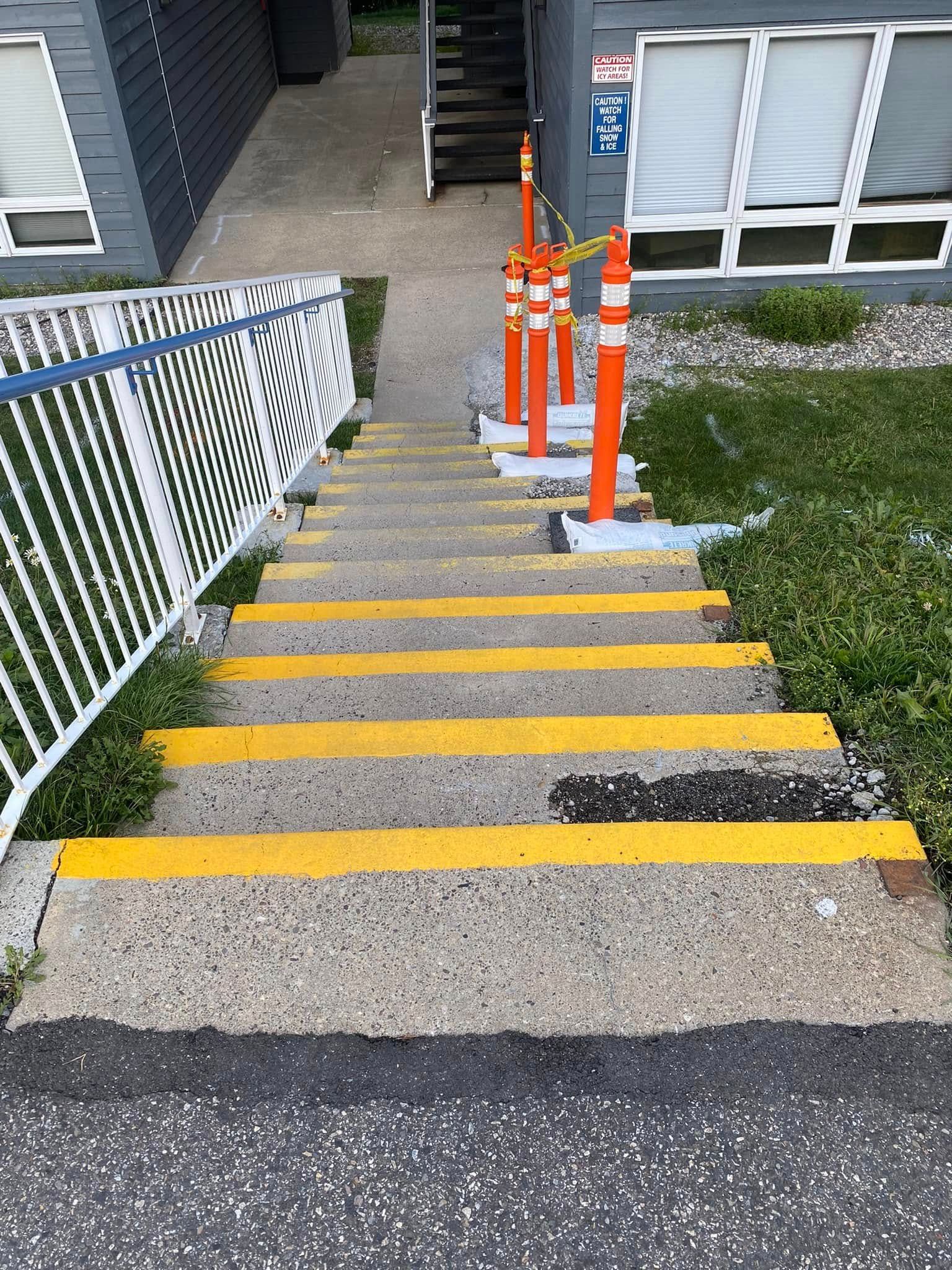 A set of stairs with yellow stripes on them leading up to a building.