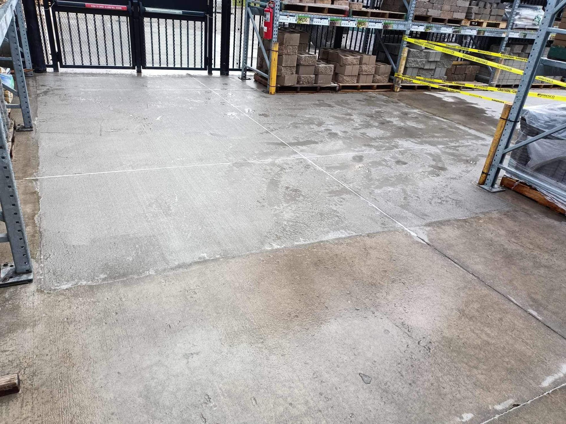 A warehouse with a lot of boxes on the floor and a gate.