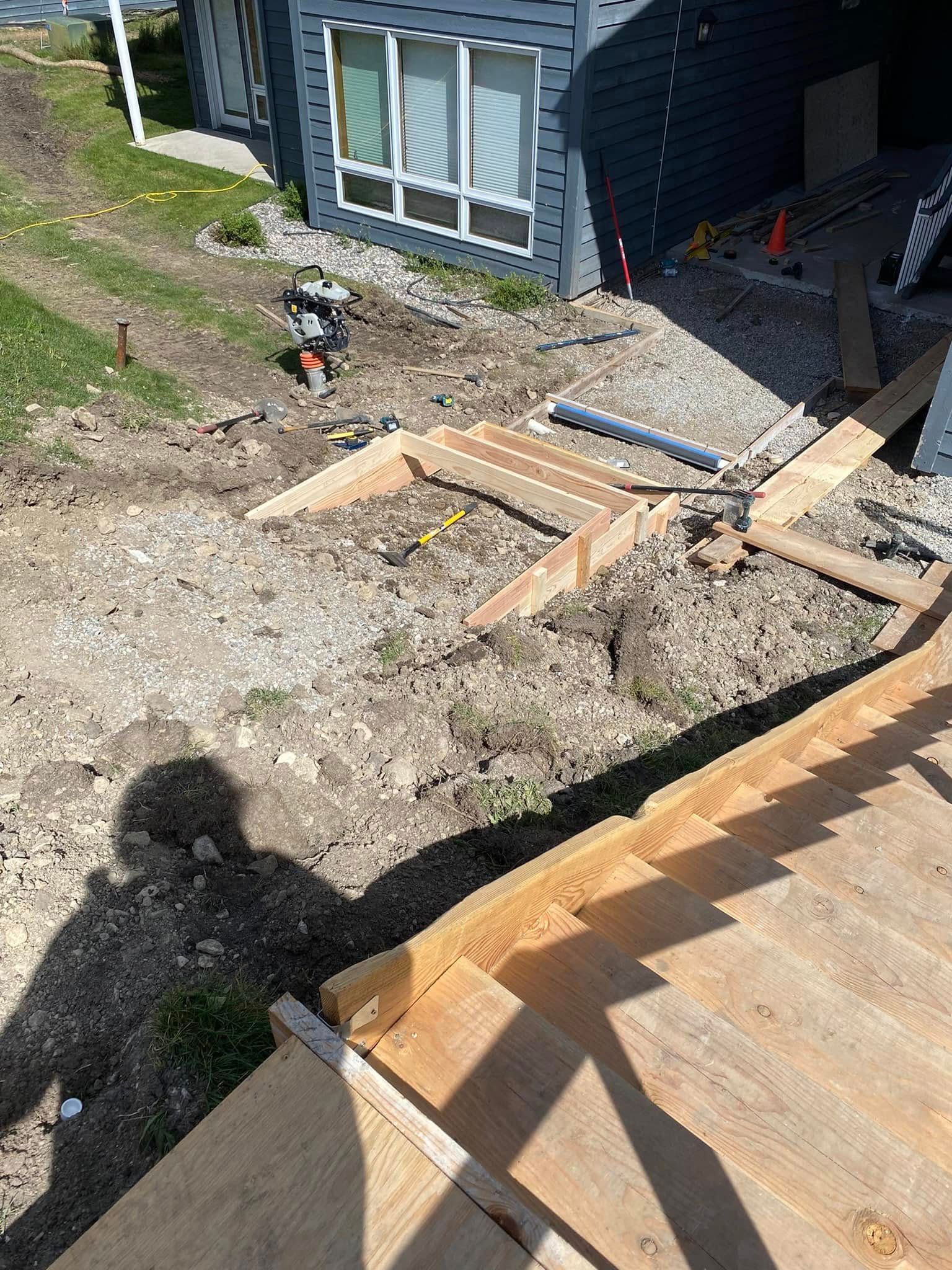 A wooden deck is being built in front of a house.