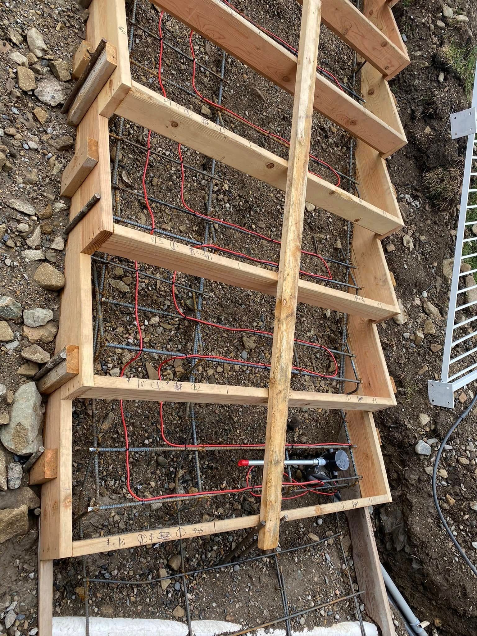 A wooden ladder is sitting on top of a pile of rocks.