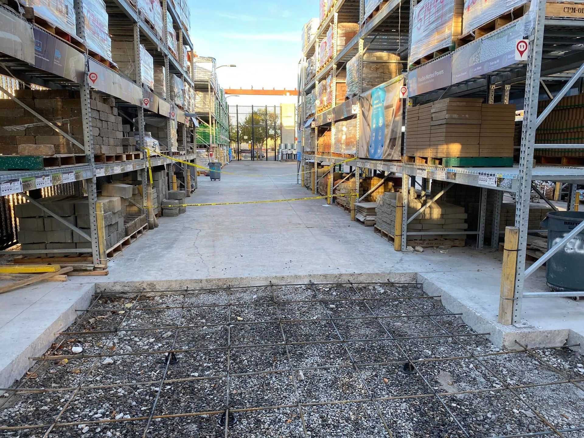 A warehouse filled with lots of shelves and pallets of bricks.