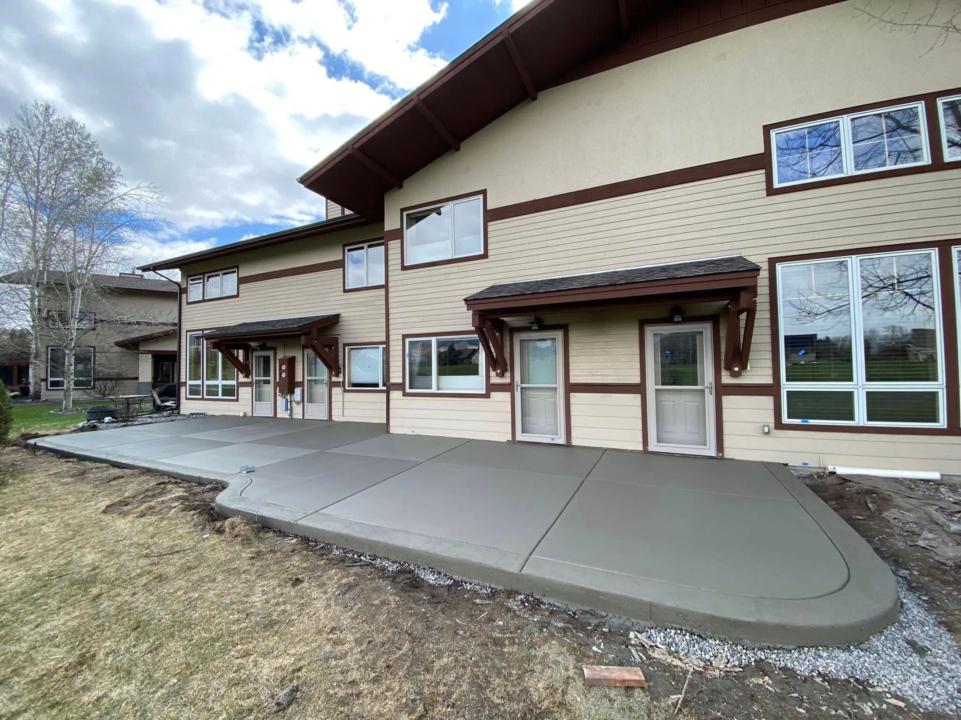 A large house with a concrete patio in front of it.