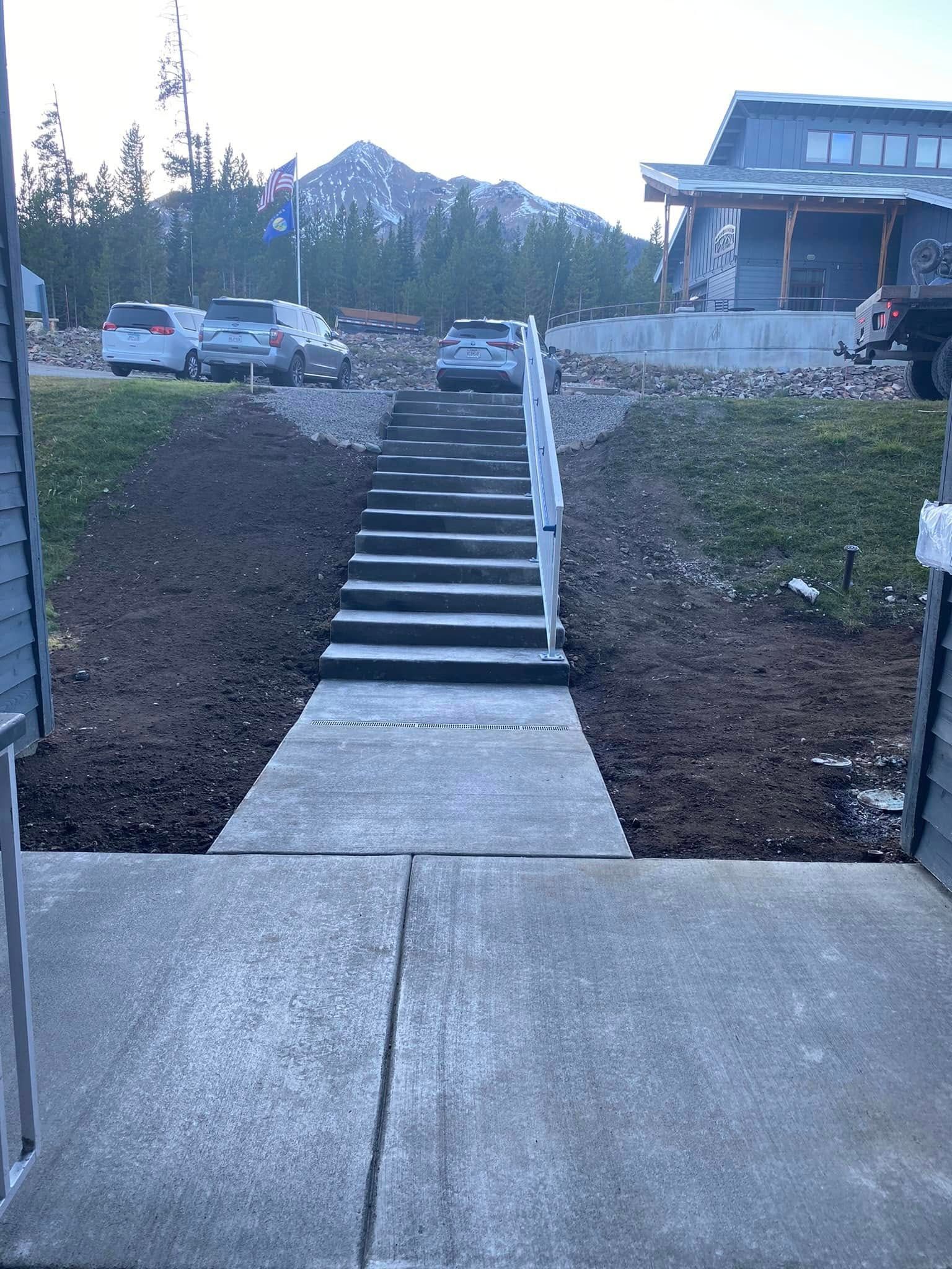 A concrete walkway with stairs leading up to a house.