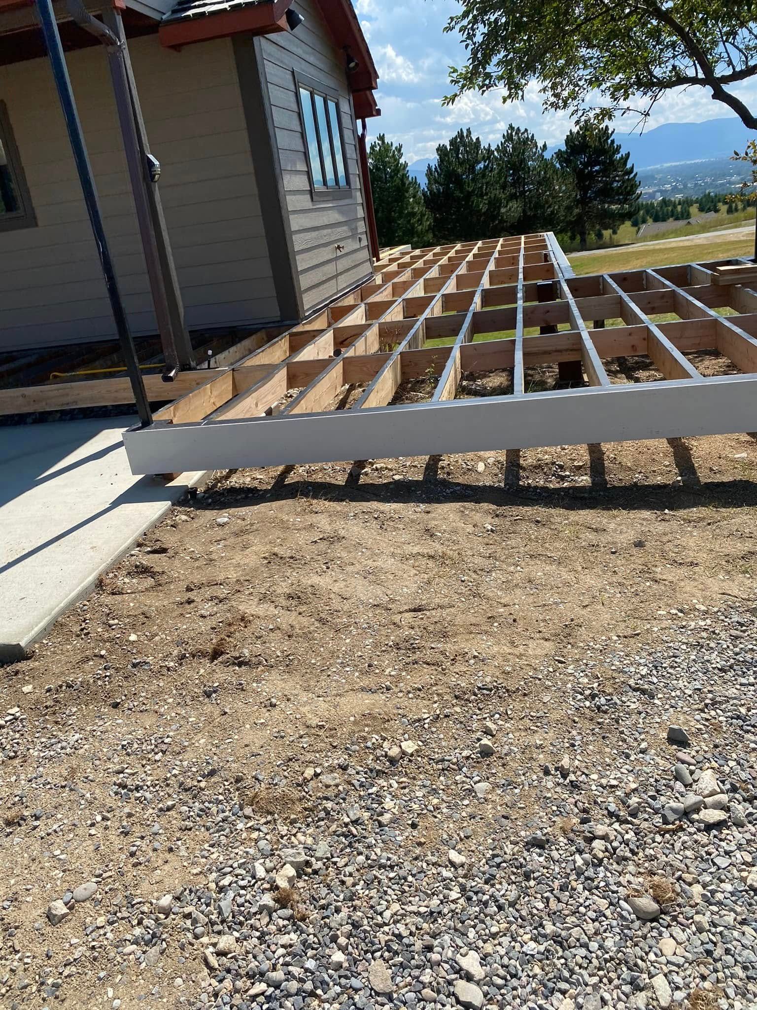 A wooden deck is being built in front of a house.