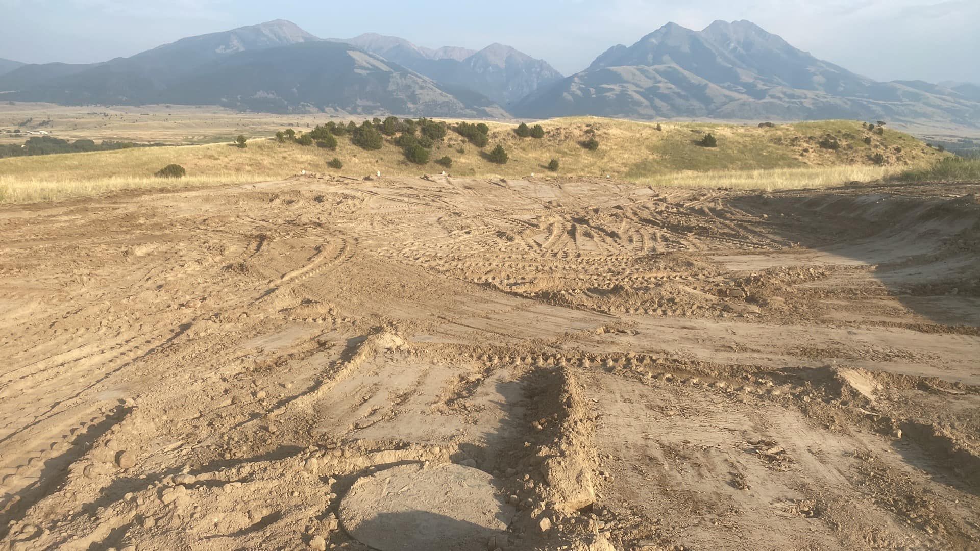 A dirt road with mountains in the background.