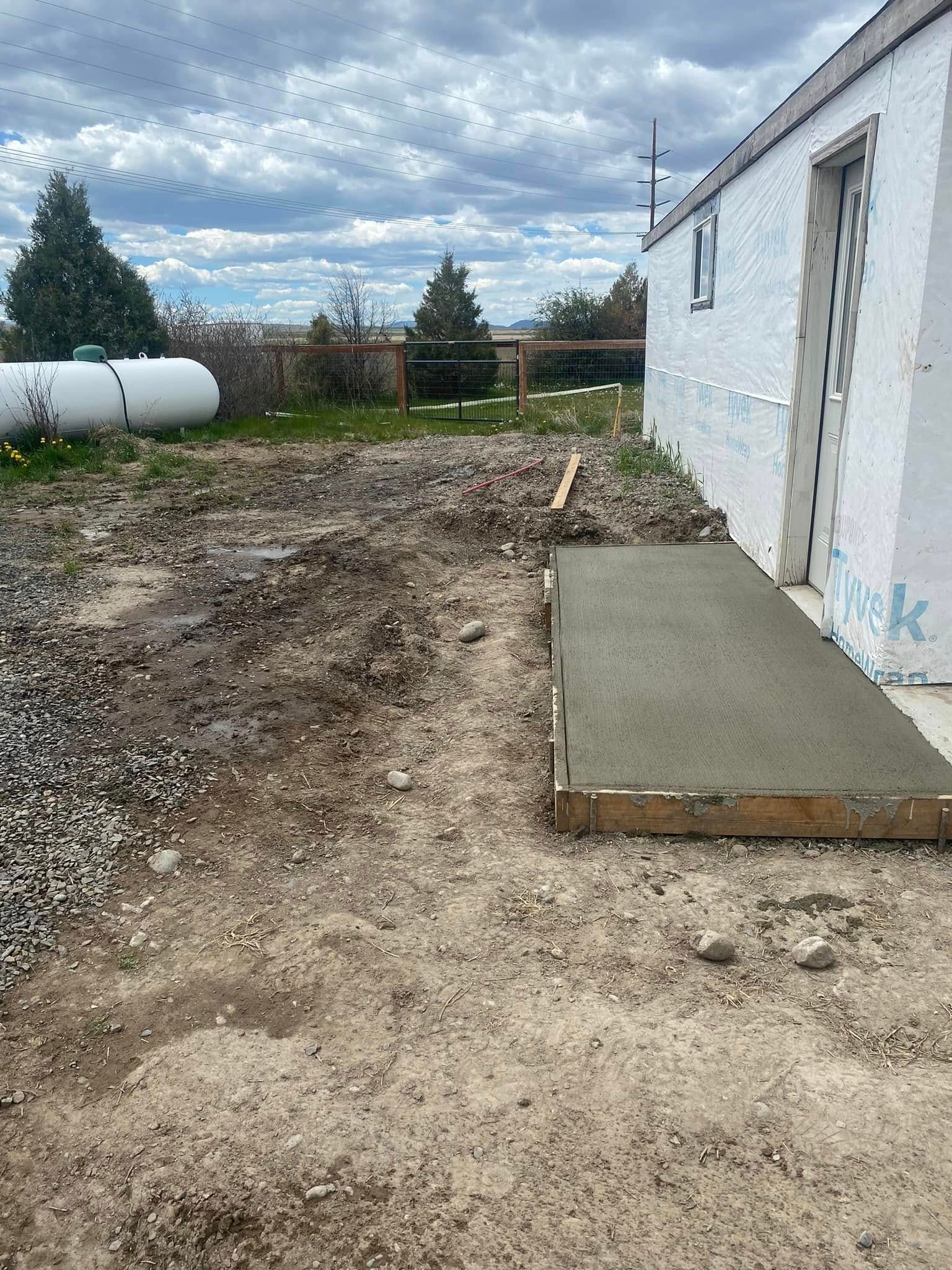 A concrete walkway is being built in front of a white building.
