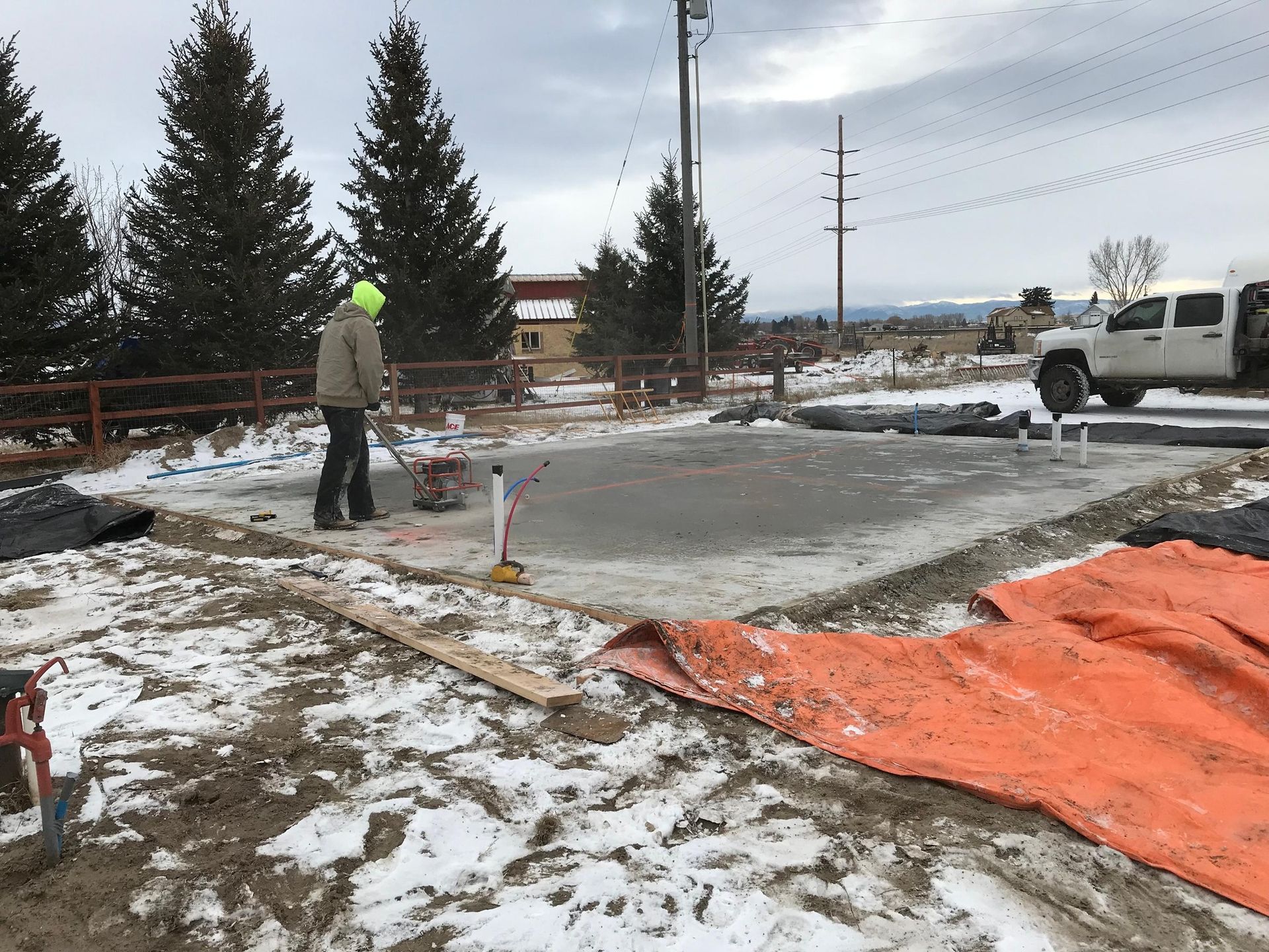 A man is working on a concrete slab in the snow.
