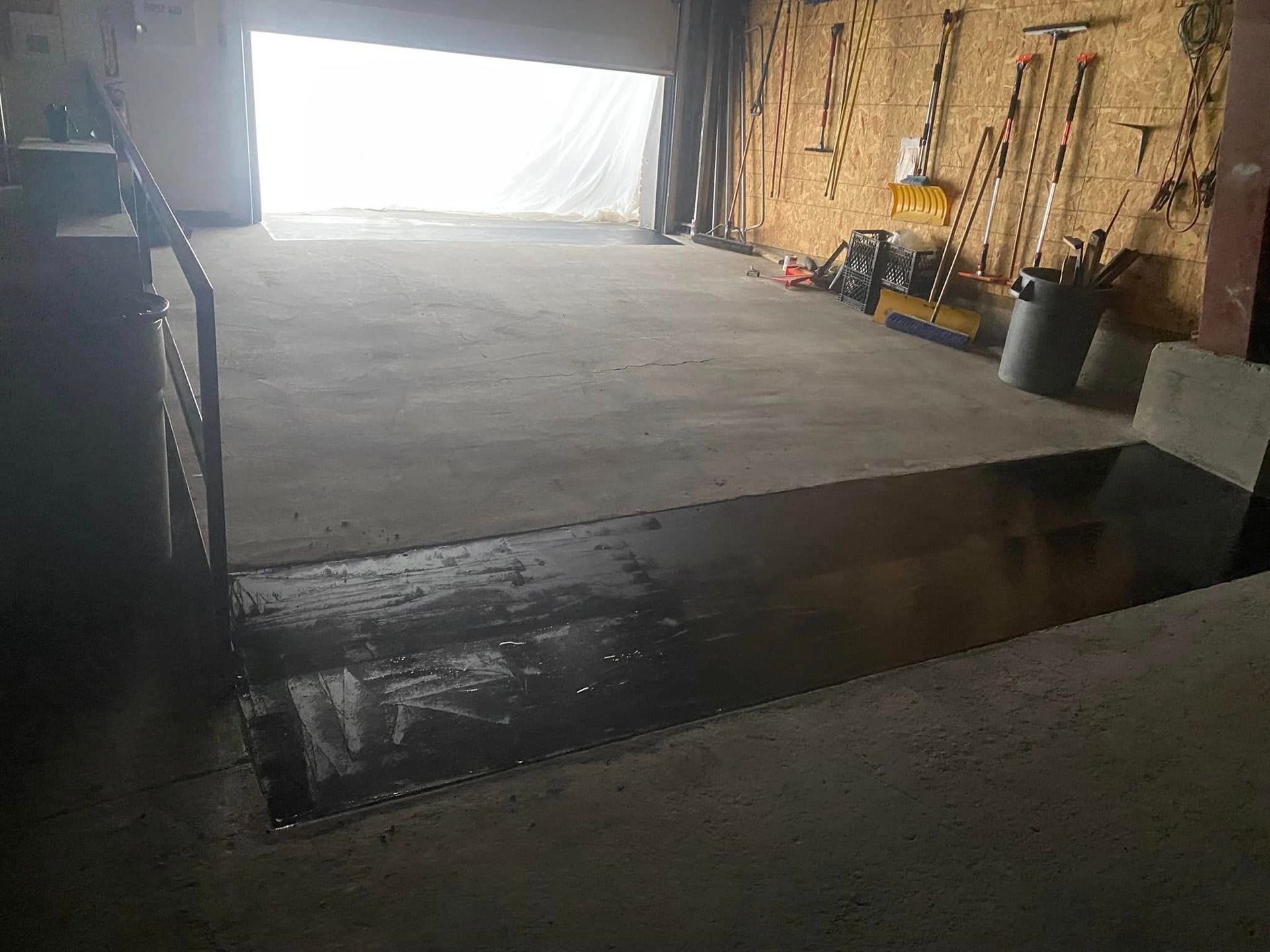 A large empty garage with a lot of tools on the wall.