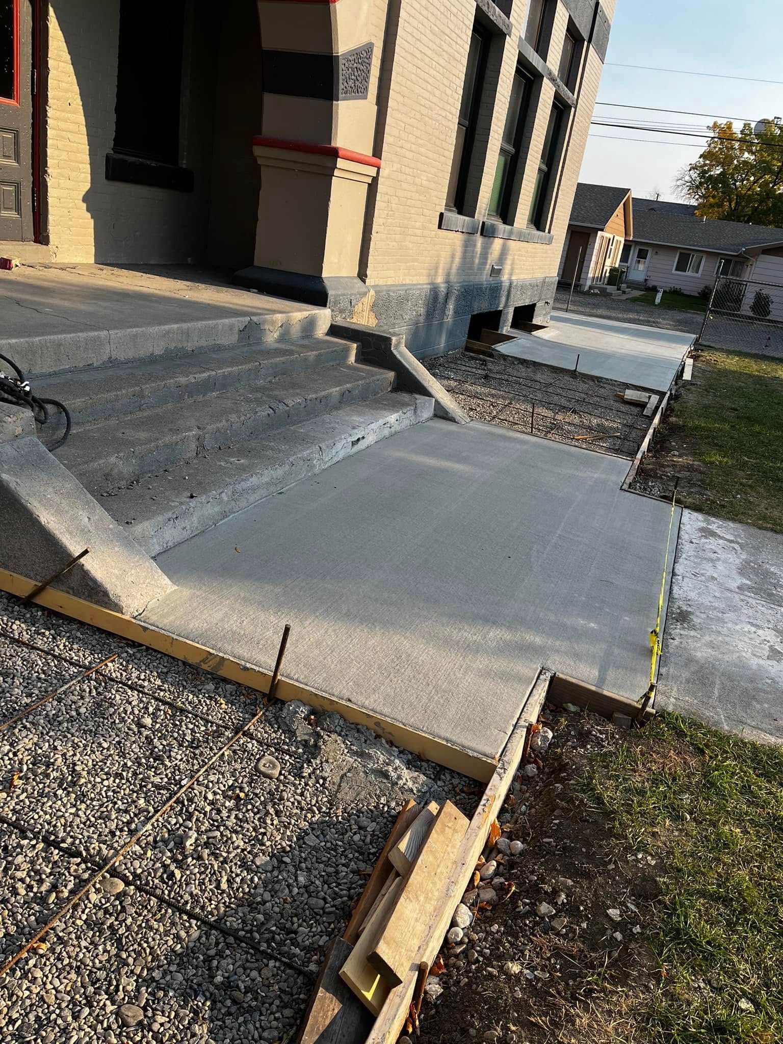 A concrete walkway is being built in front of a house.