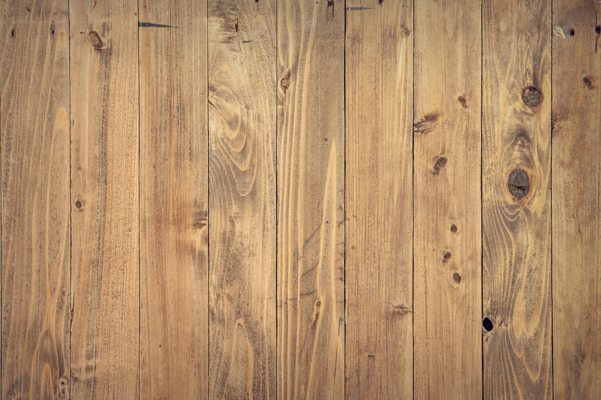 Wooden planks, vertical, with knots and grain detail, warm brown tones.