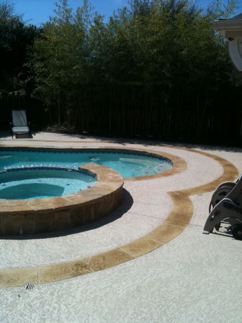 A large swimming pool with a hot tub in the middle