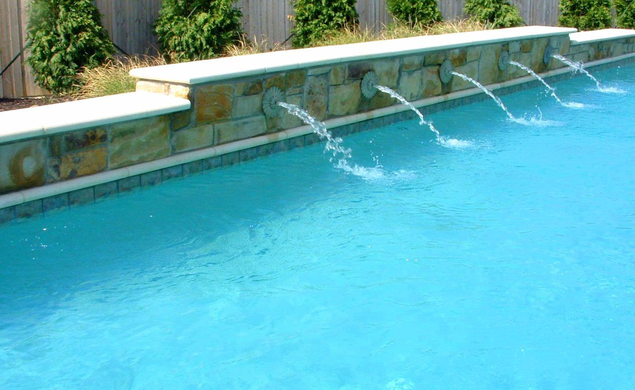 A swimming pool with a stone wall