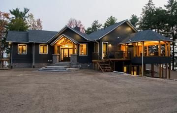 A large house with a lot of windows is lit up at night.