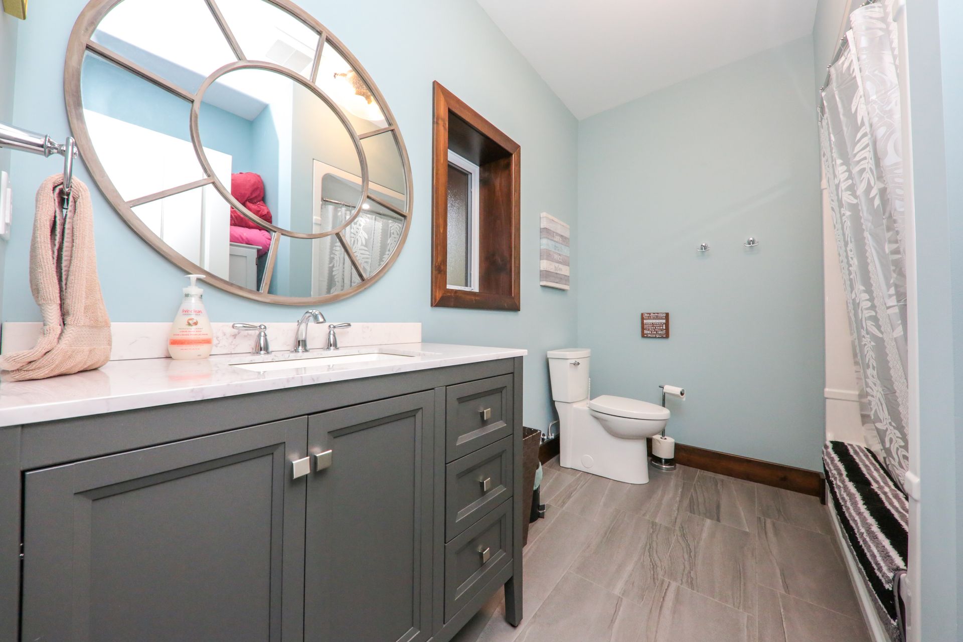 A bathroom with two sinks , a toilet , and a large mirror.