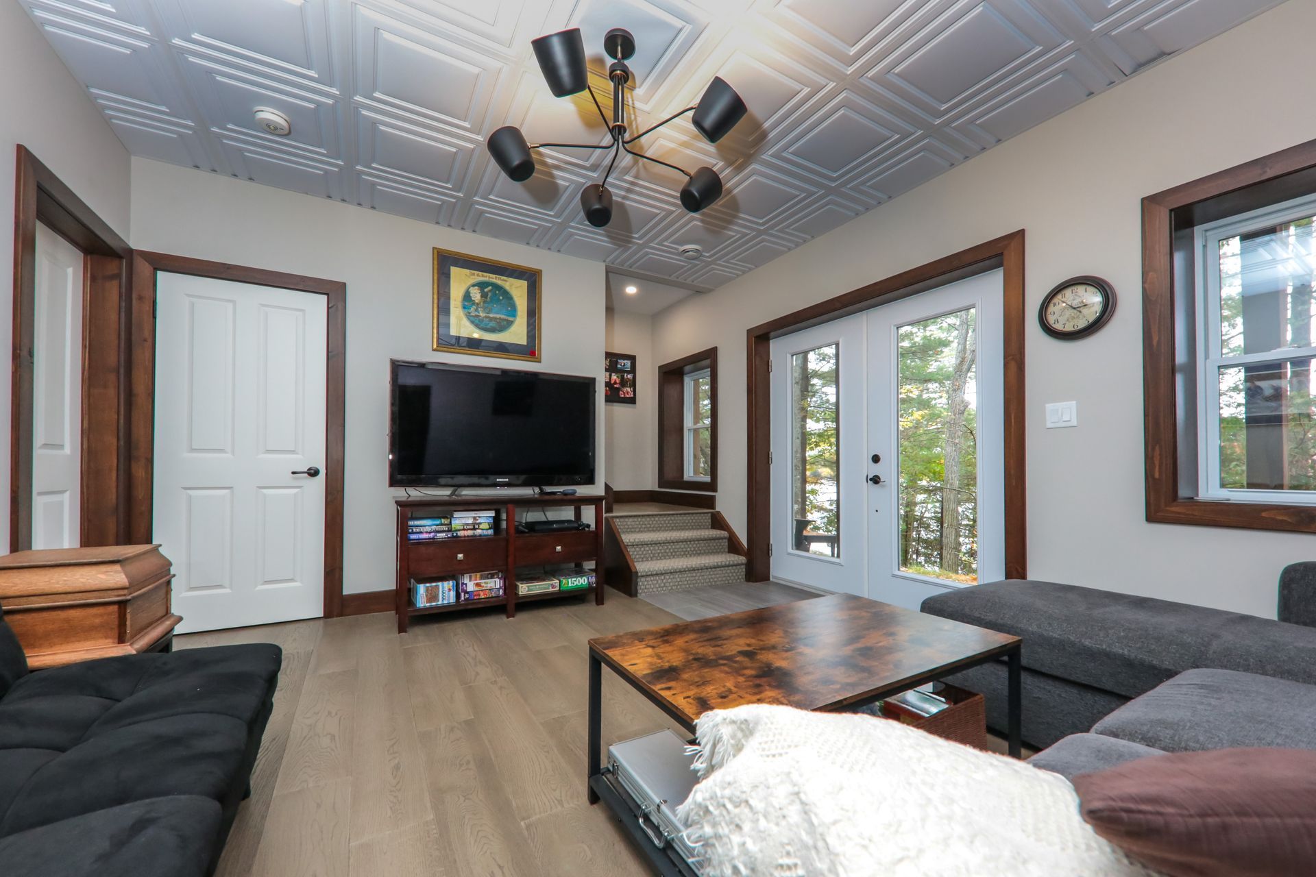 A living room with a couch , table , television and stairs.