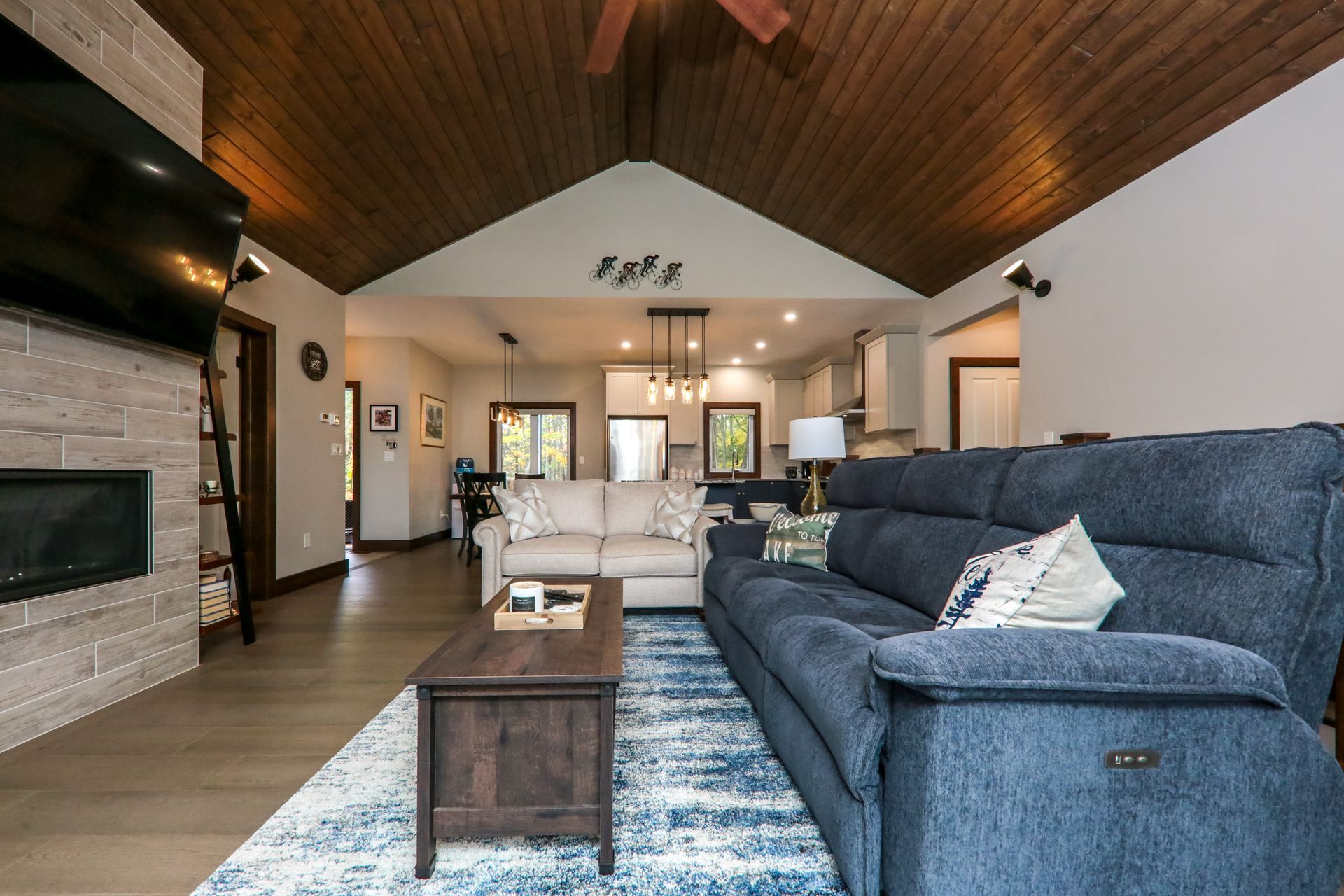 A living room with a couch , coffee table , television and fireplace.