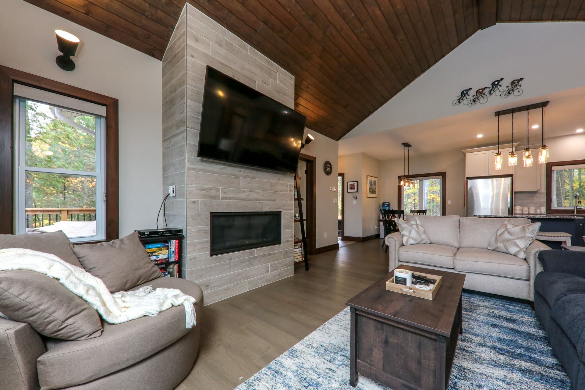 A living room with a couch , chair , coffee table and television.