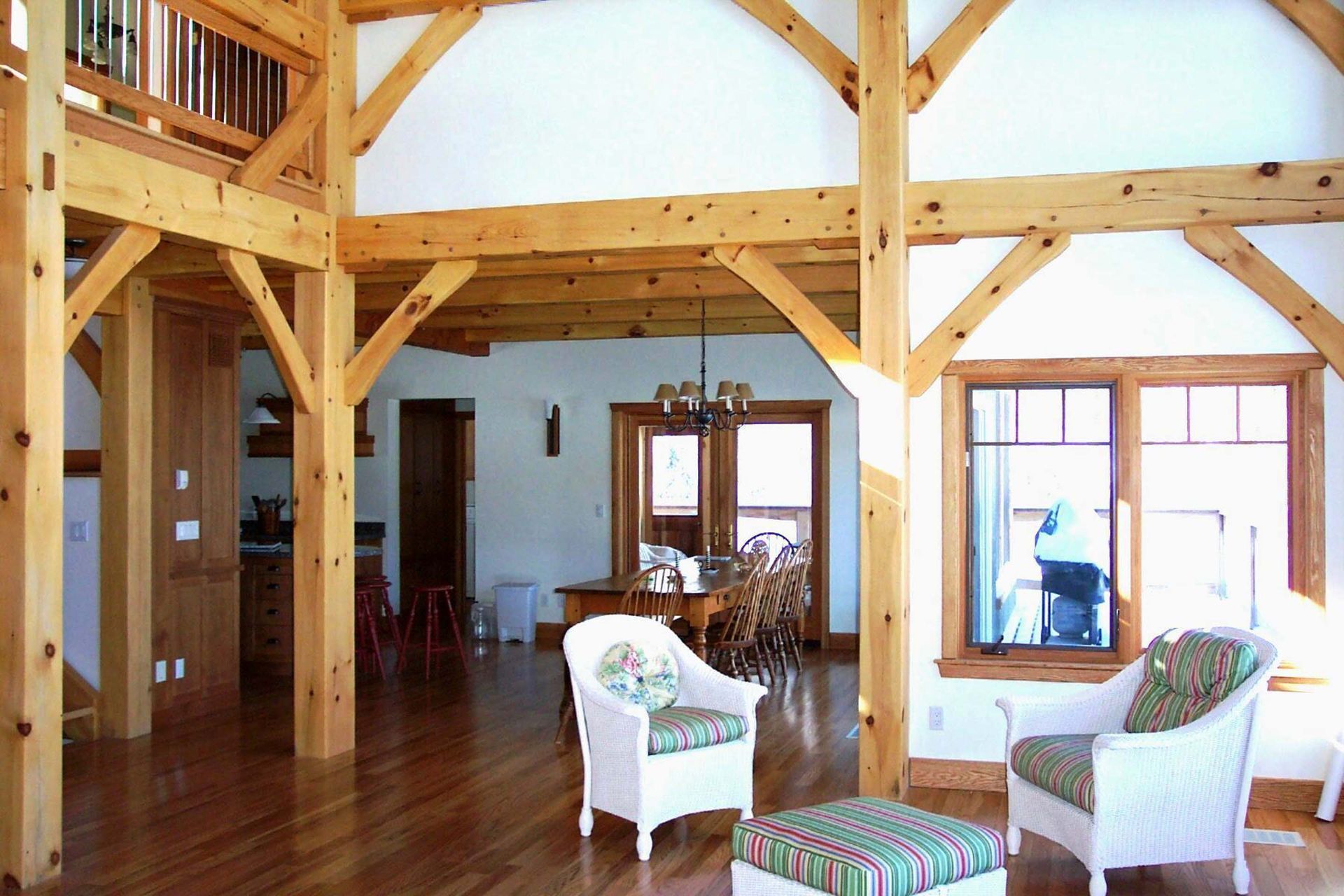 A living room with wooden beams and white chairs