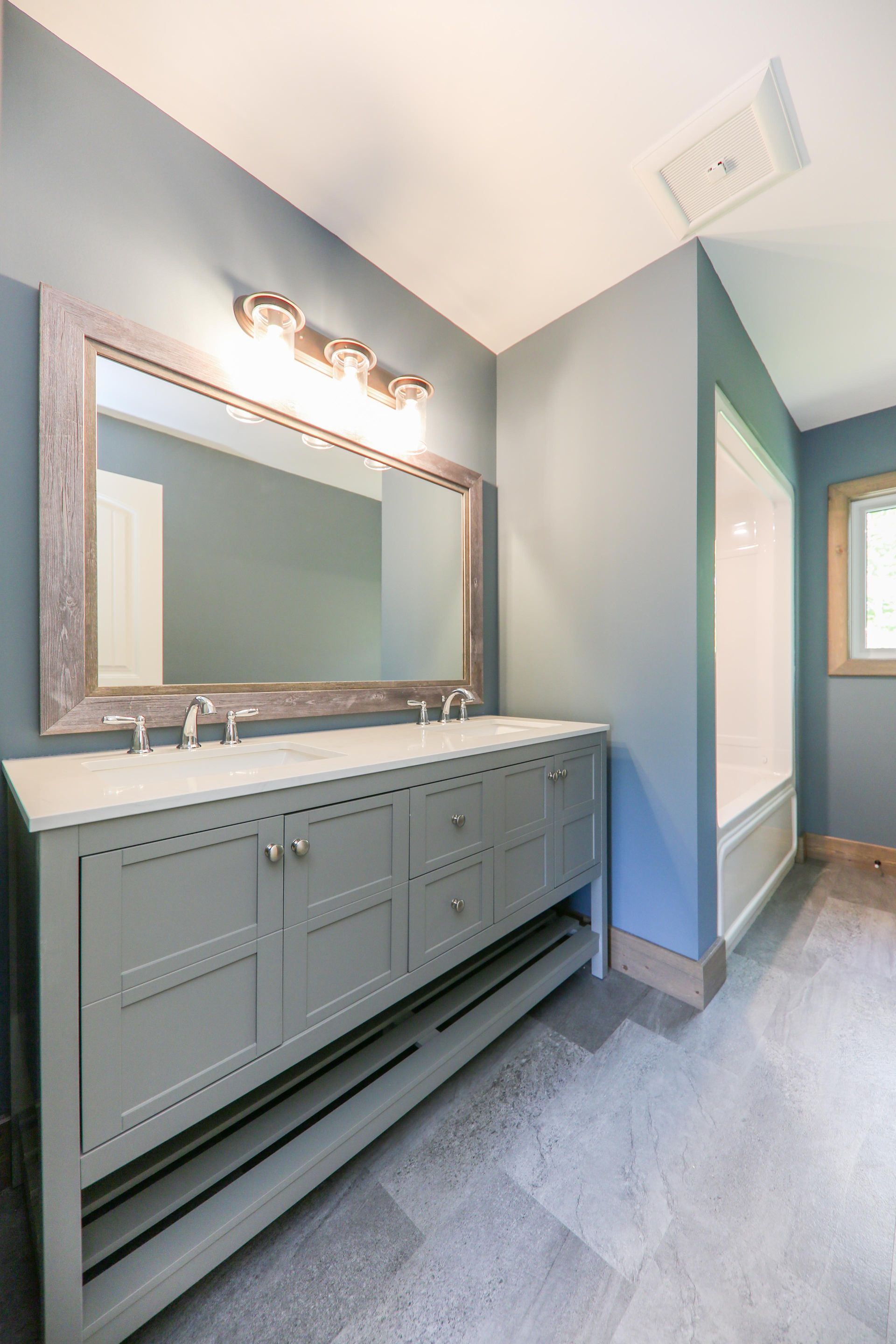 A bathroom with two sinks and a large mirror.